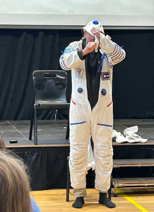 Pete pulling the astronaut costume over his head