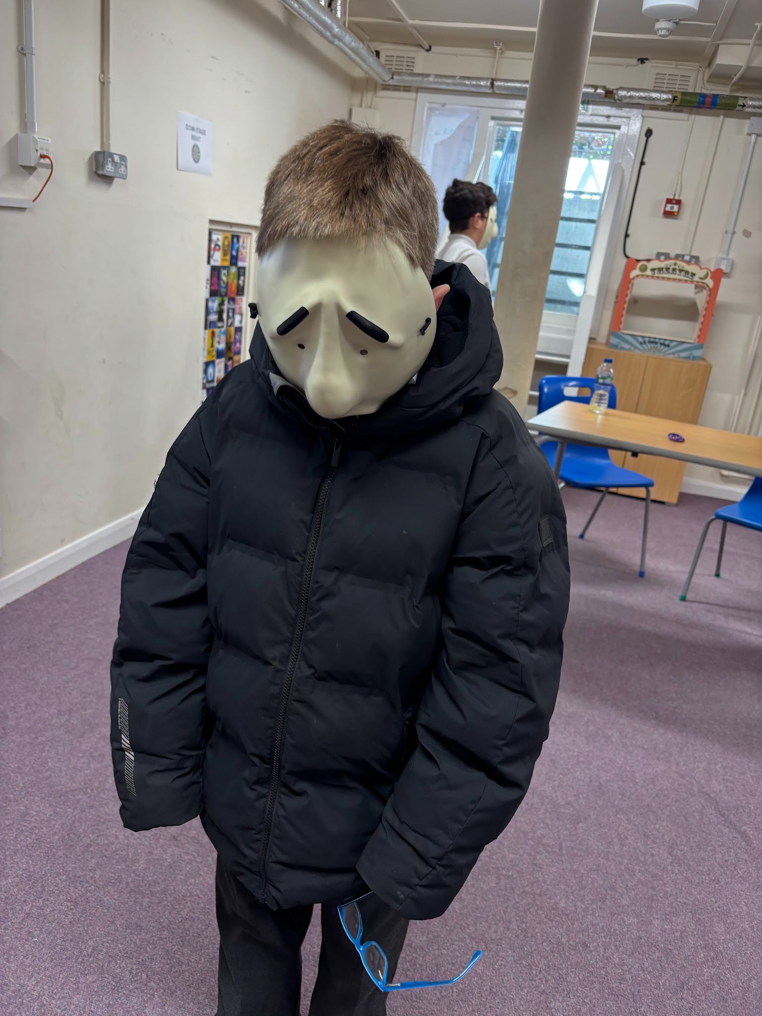 Boy acting wearing a white mask with a sad face
