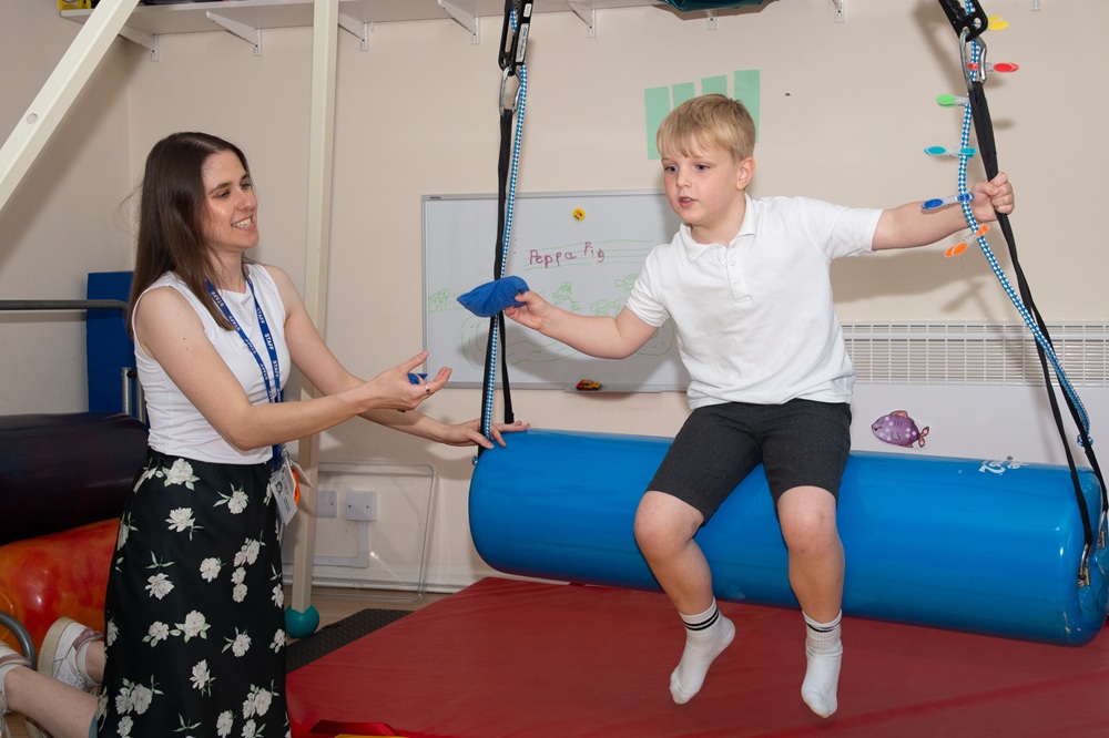 Occupational Therapist with student on swing