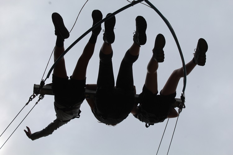 Three silhoutted on the high swing