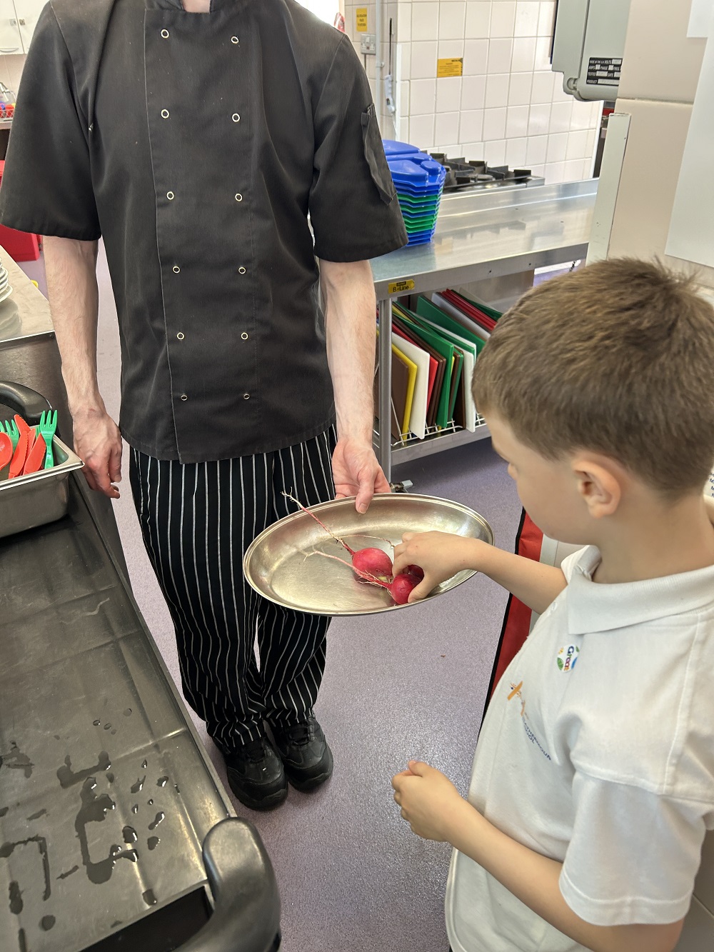 Students taking a radish they've grown to the kitchen