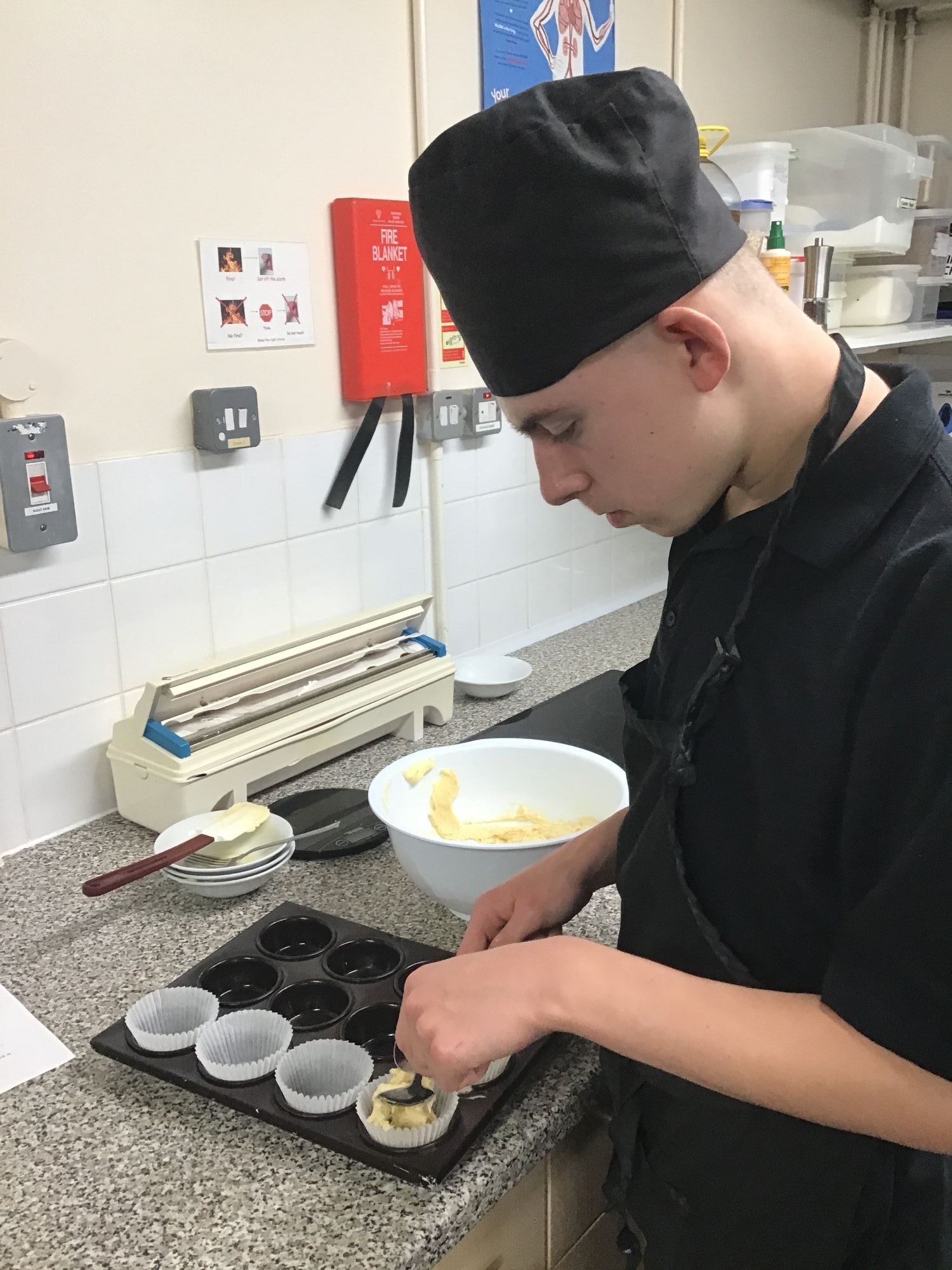 Student filling cake cases