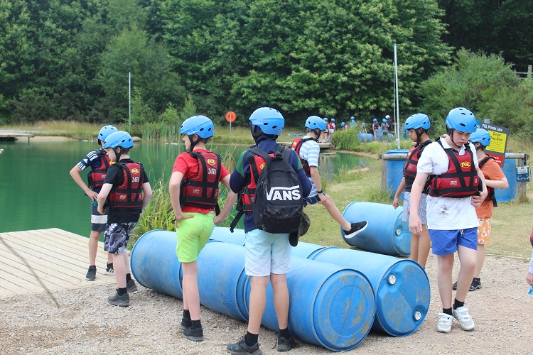 Students building a raft with rope and barrells