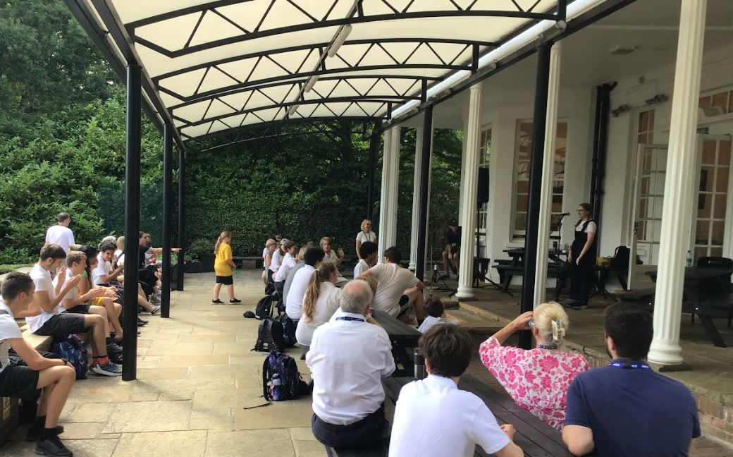 Staff and students sitting on the terrace watching the showcase