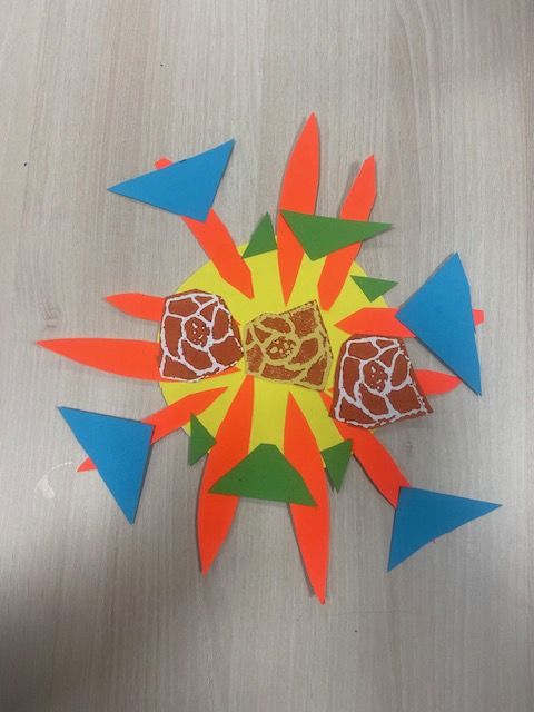 Fllower with yellow centre and green, orange and blue petals.