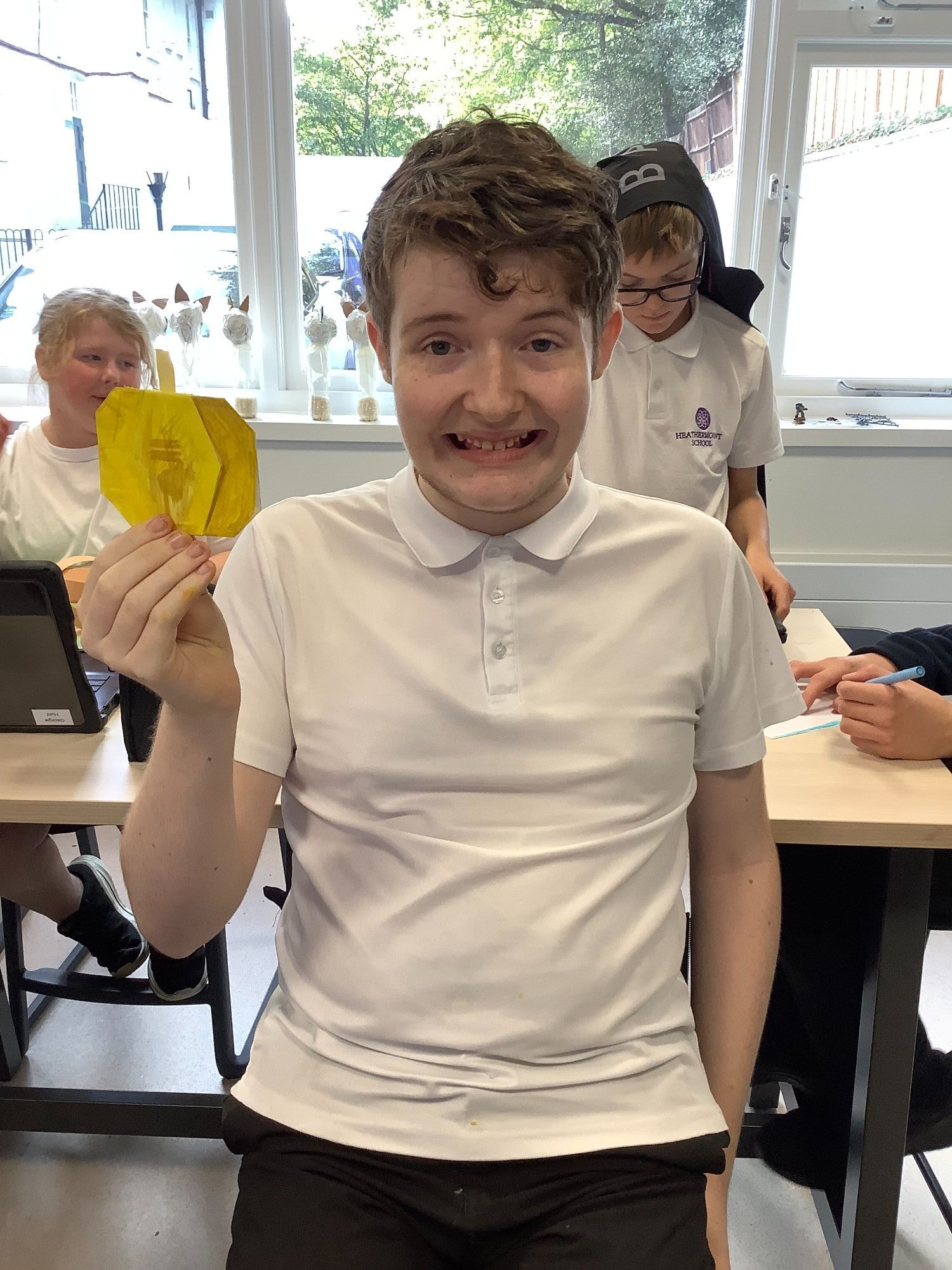 Earth student happily holding up his halloween craft