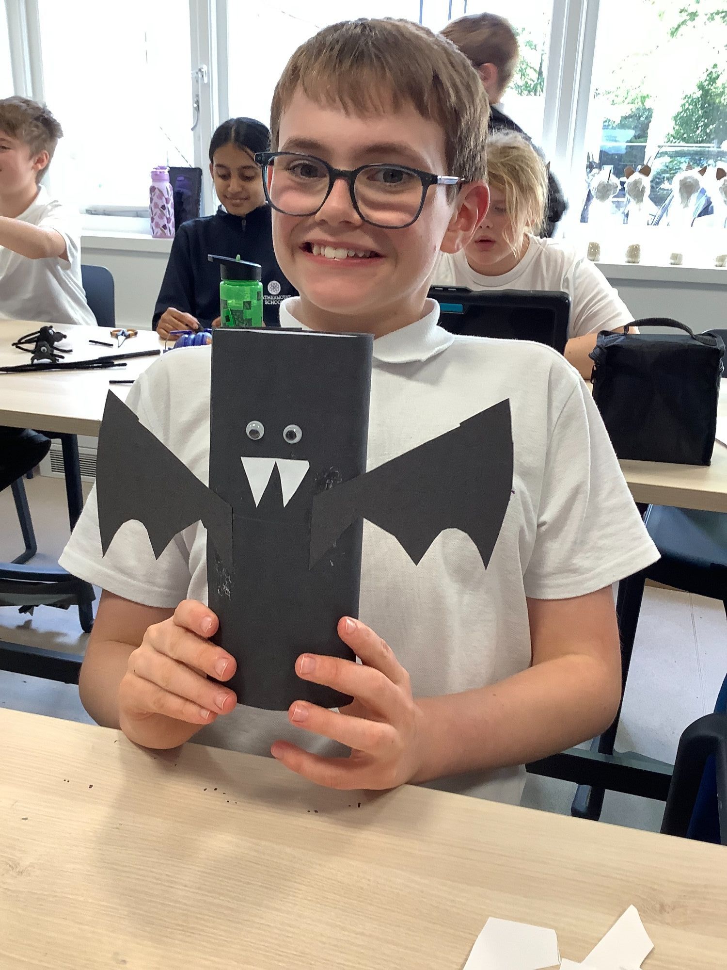 Bat craft Boy from Earth smiling and holding up the bat he has made