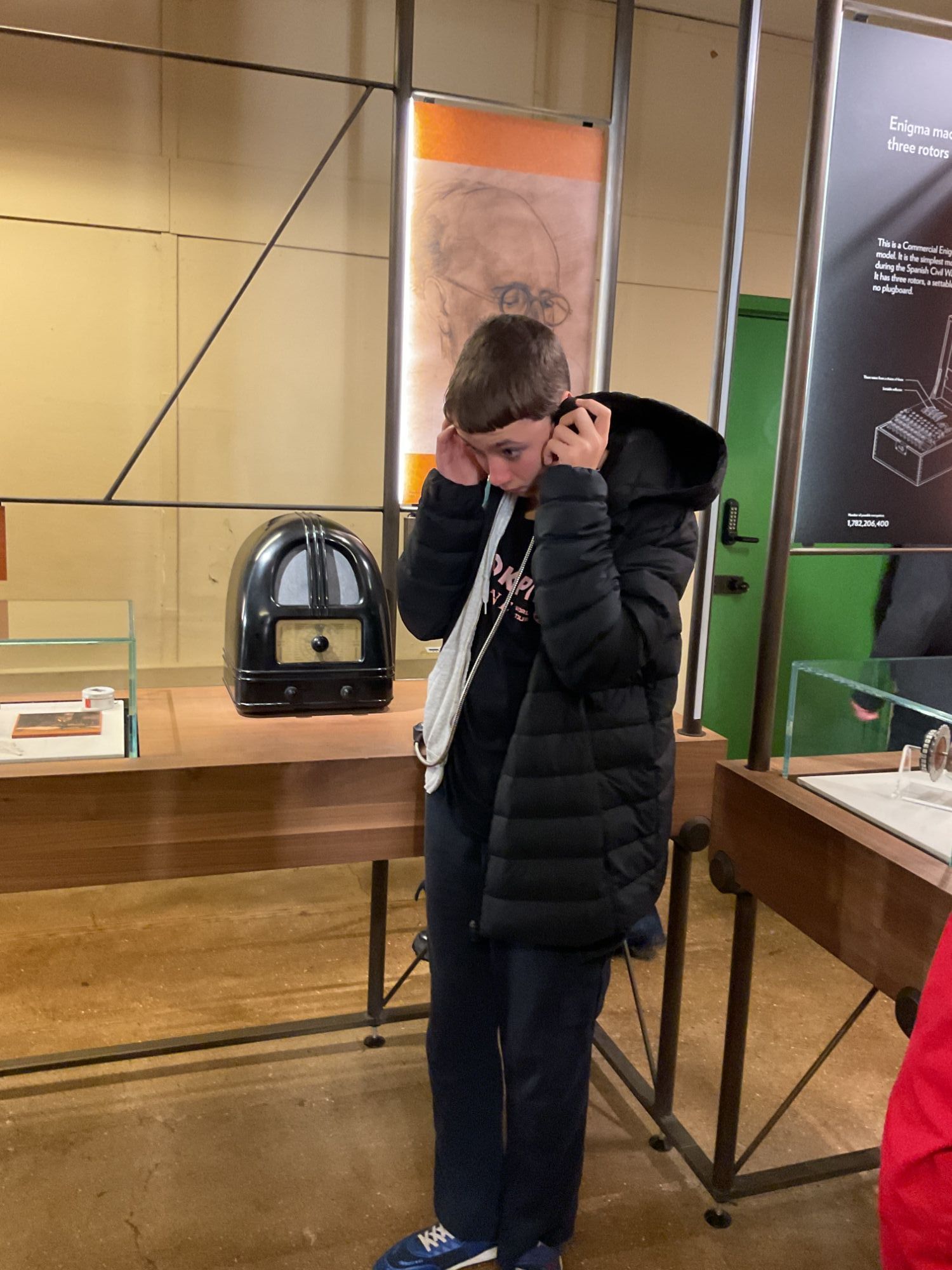 Student wearing headphones and listening to an exhibit at the museum