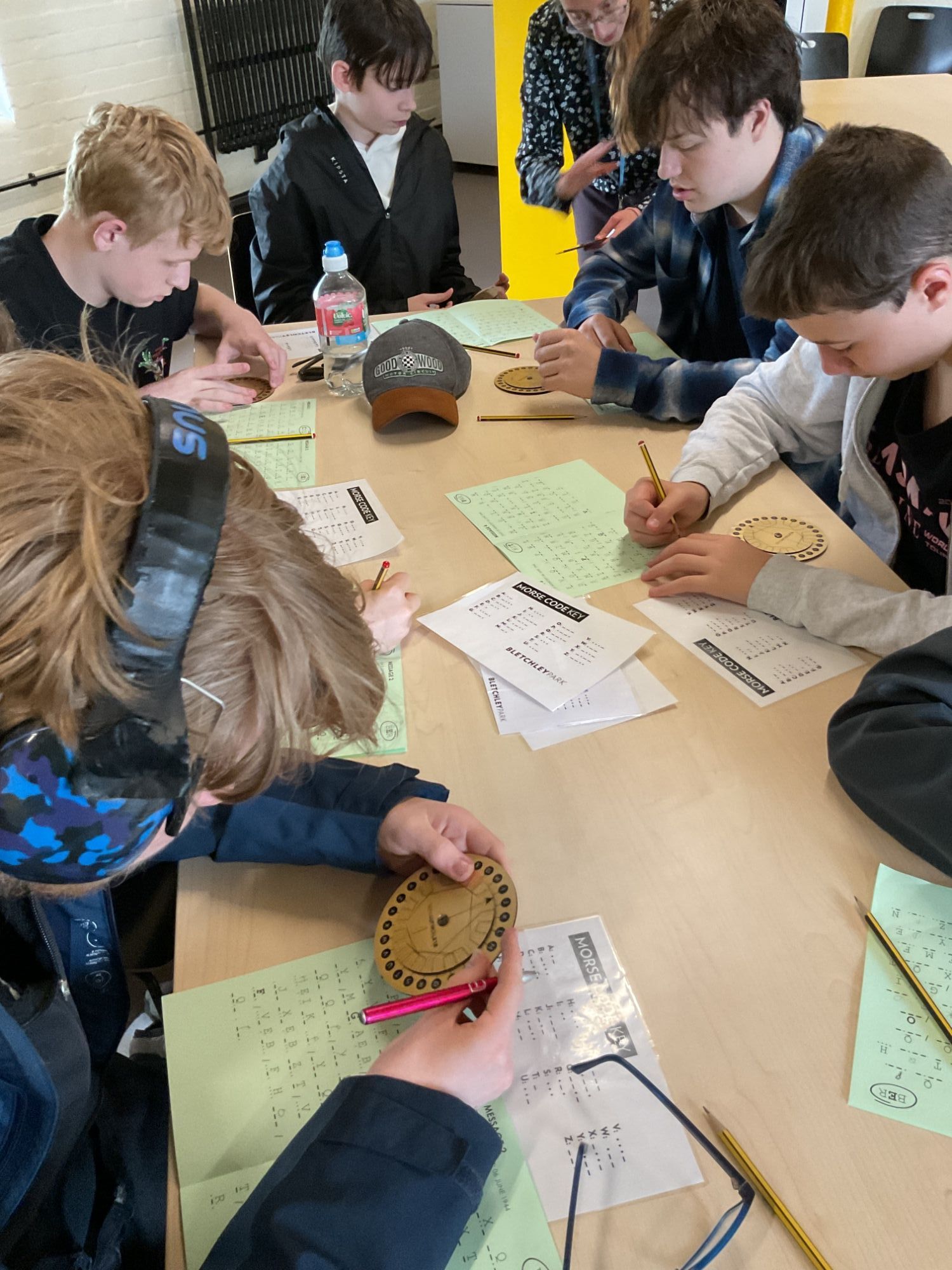 Students sat at a table using disks to solve codes