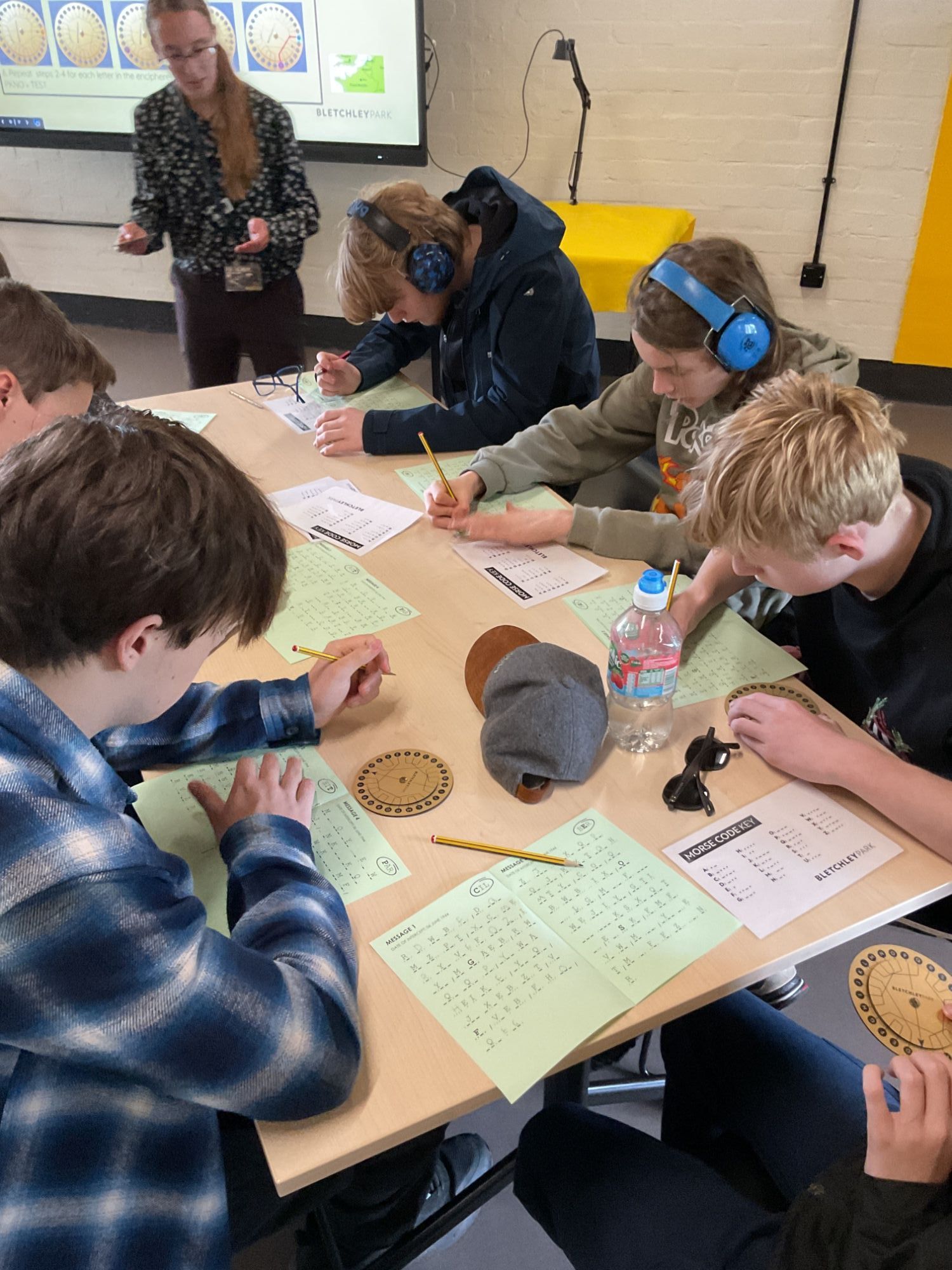 Group of students working at a desk to decipher codes