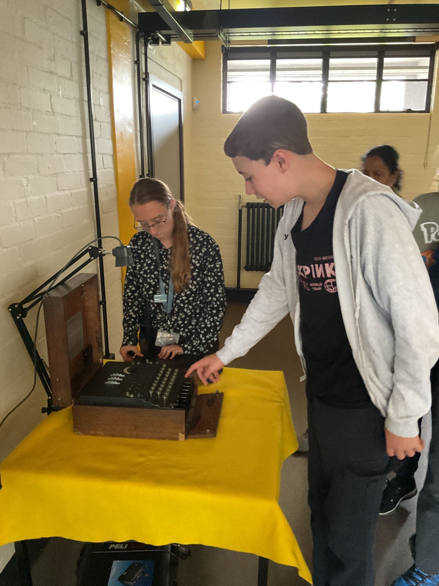 Student touching the Enigma machine