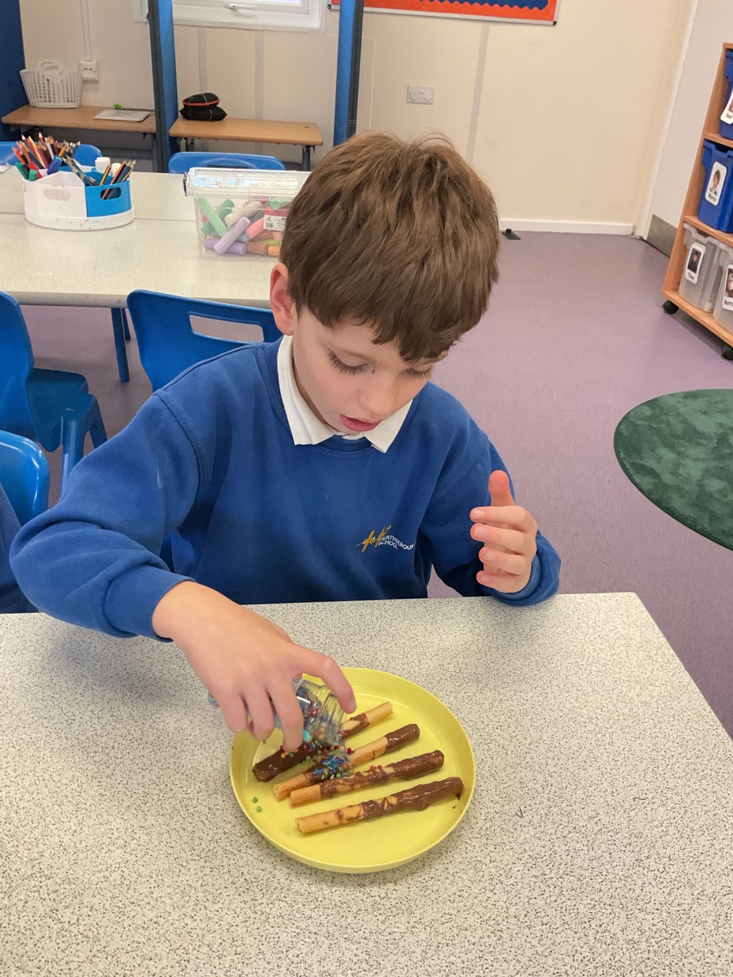 Student 2 making breadstick sparklers Another student pouring sprinkles on his sparklers