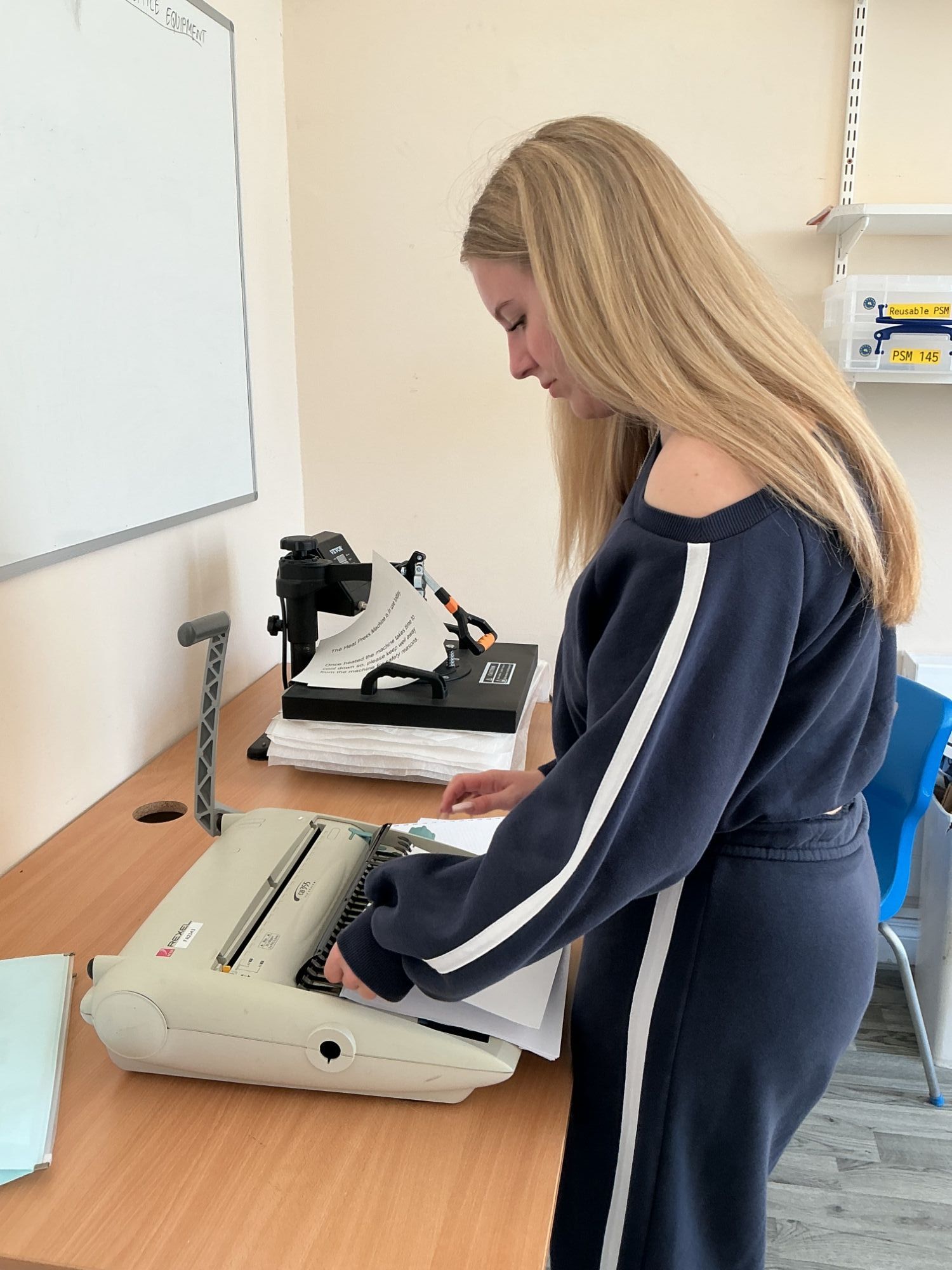 Student loading paper into a machine