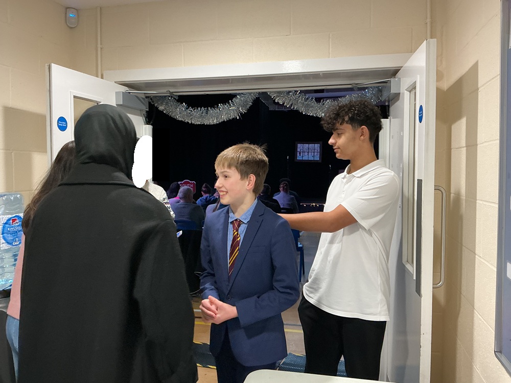 Welcome Students welcoming a guest to the school Christmas play