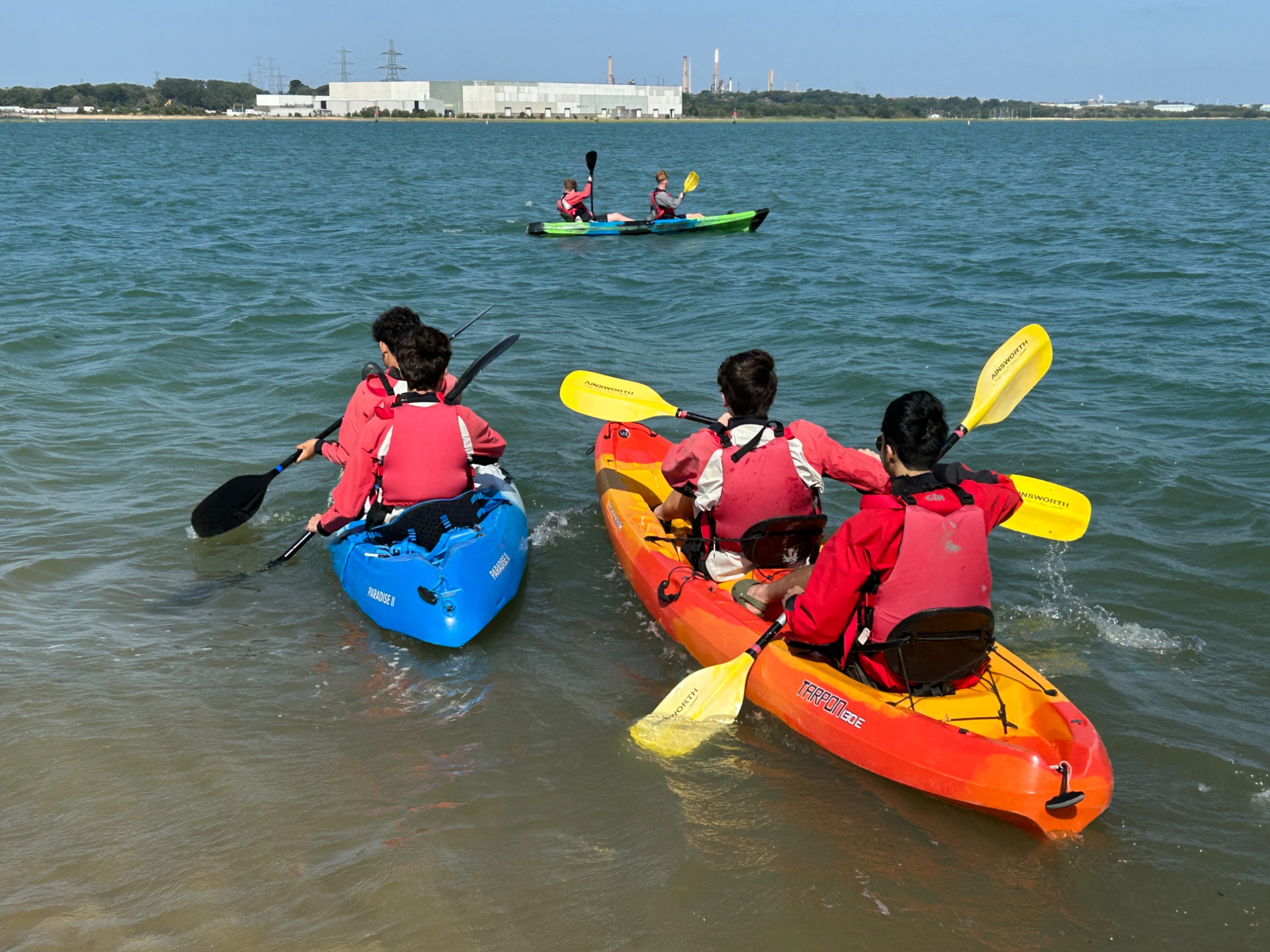 Close-up of students kayaking on the water
