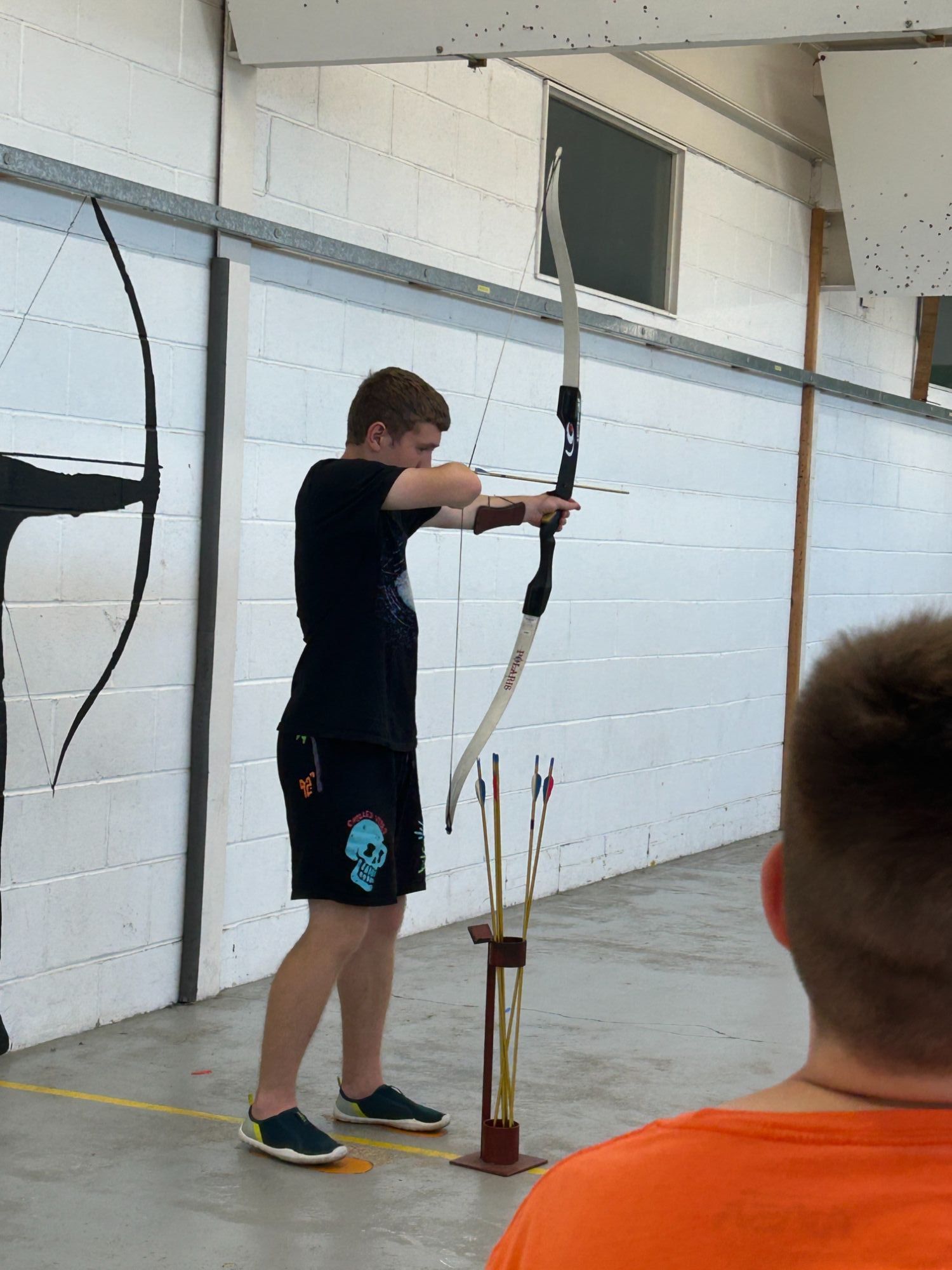 Students trying archery with a big bow