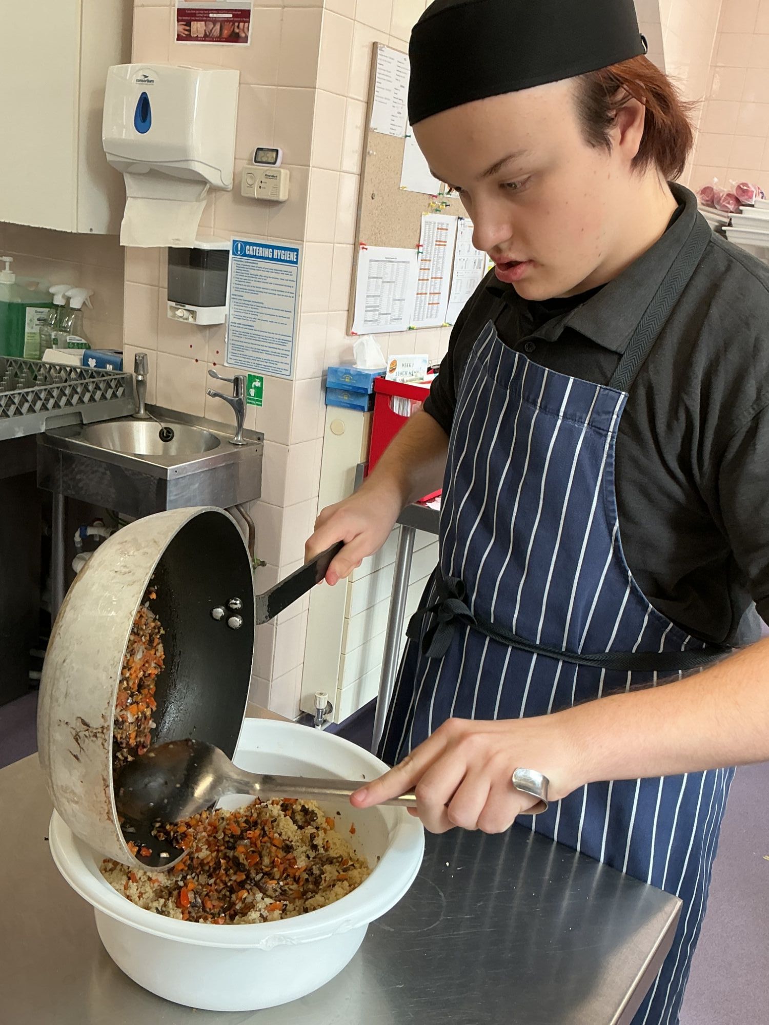 Mixing Student adding his fried vegetables to his cous cous