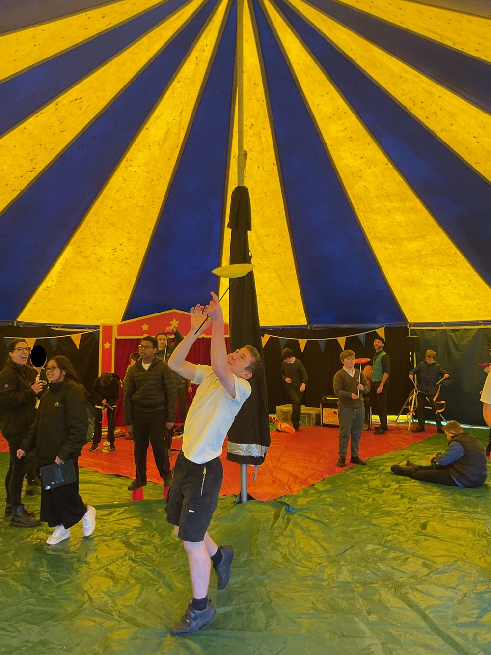 Student spinning a plate high in the air