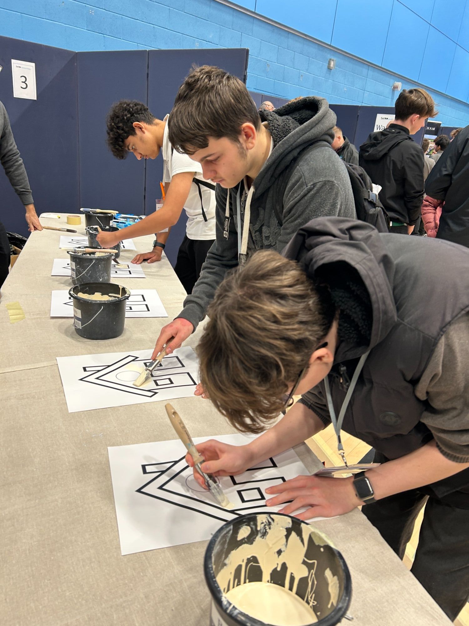 Students painting house pictures on a stall