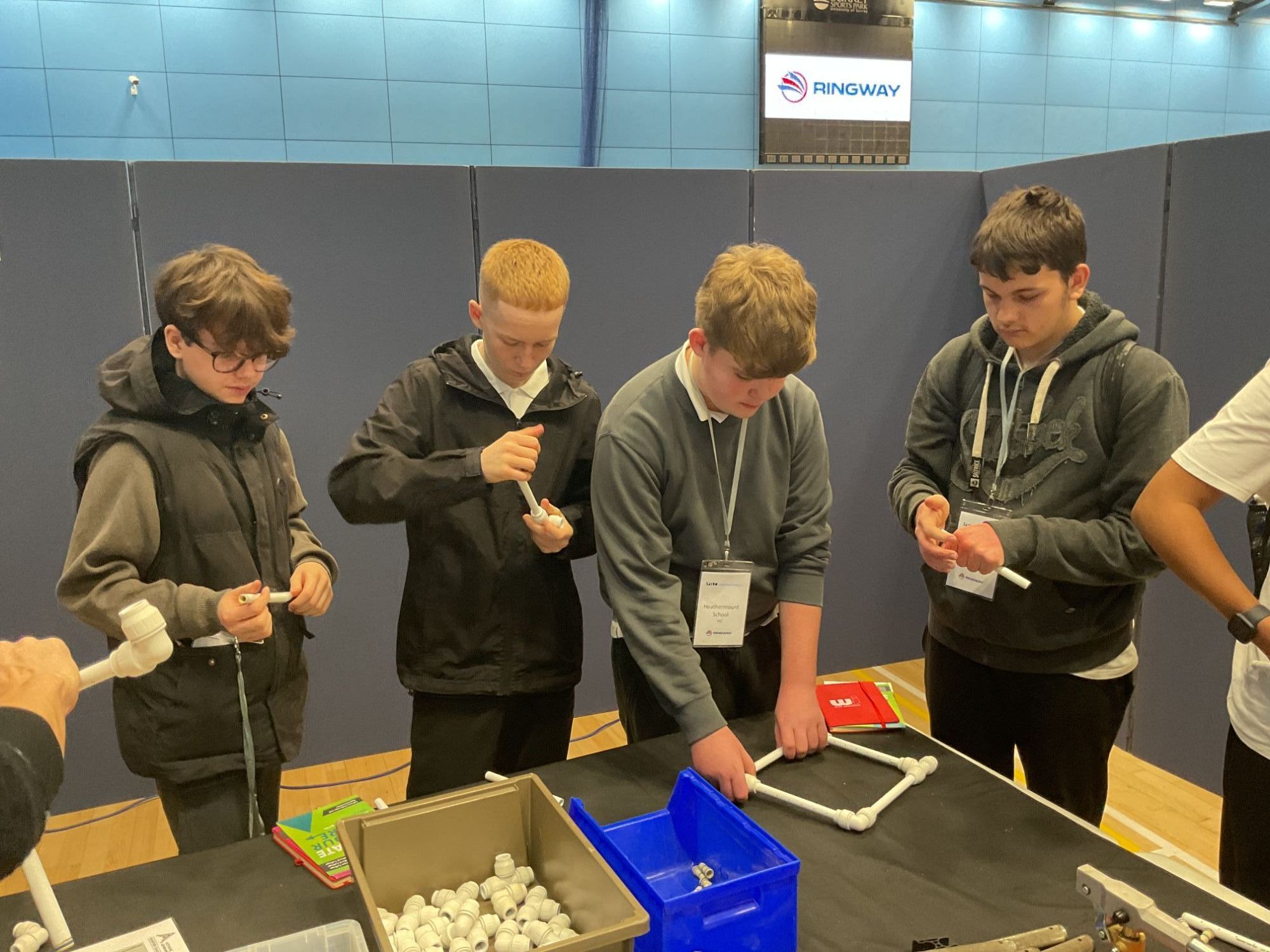 Four students constructing with pipes