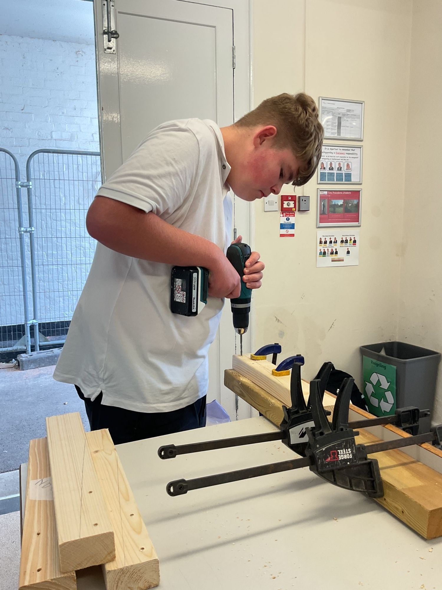 Student using a drill to make holes 