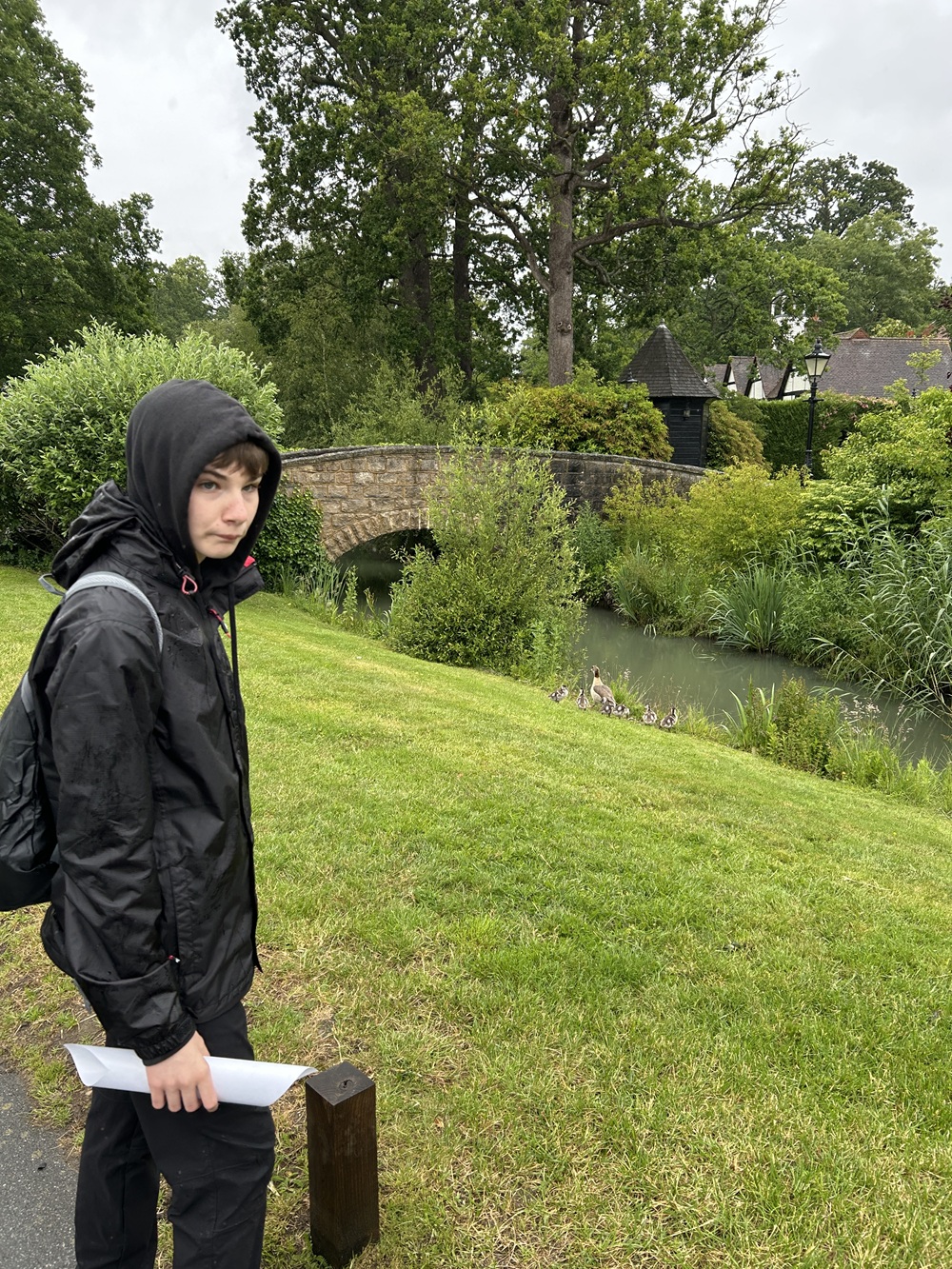 Student Student in his rain coat standing by a river