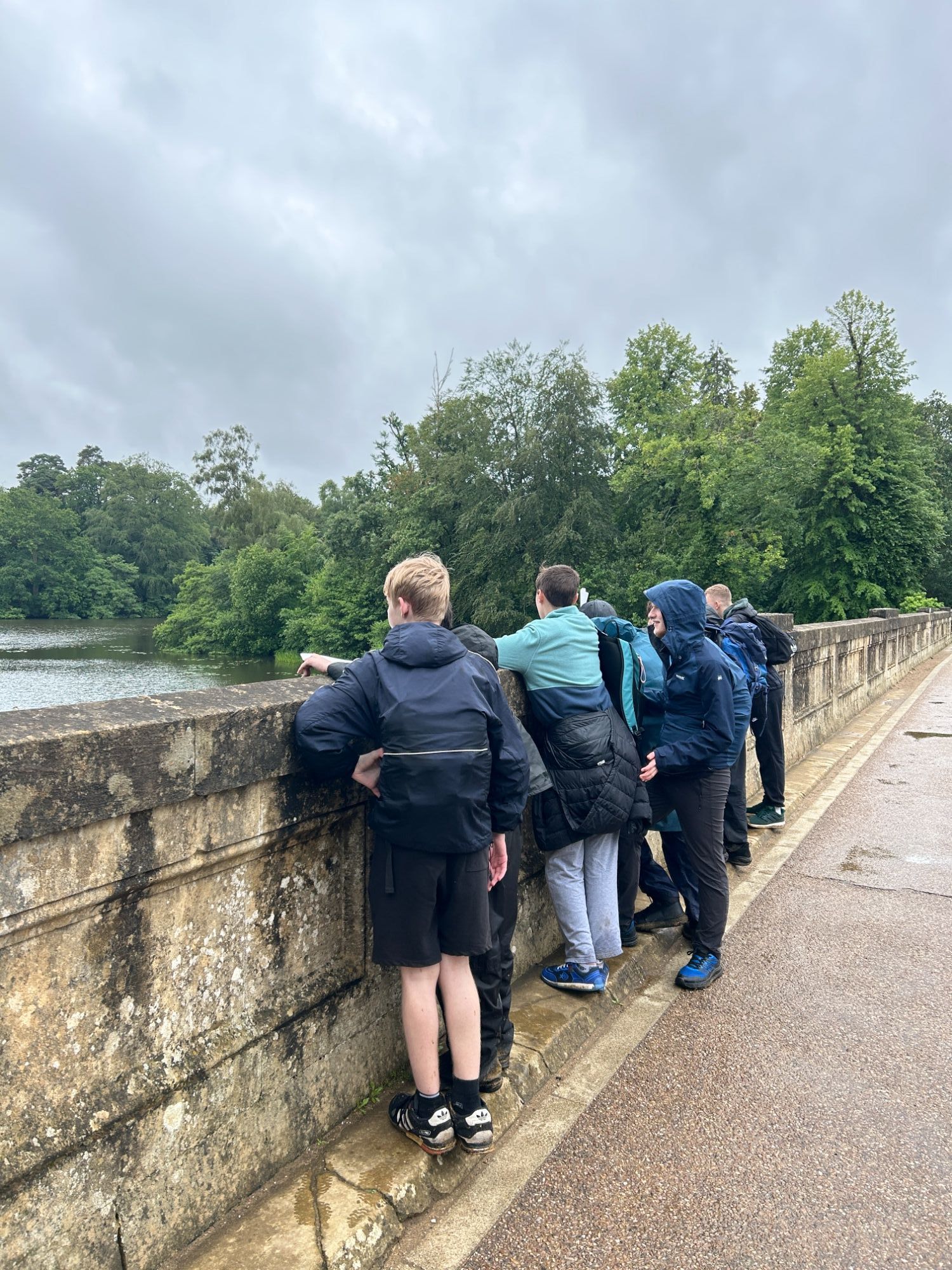 Group of students on a bridge looking out over the river