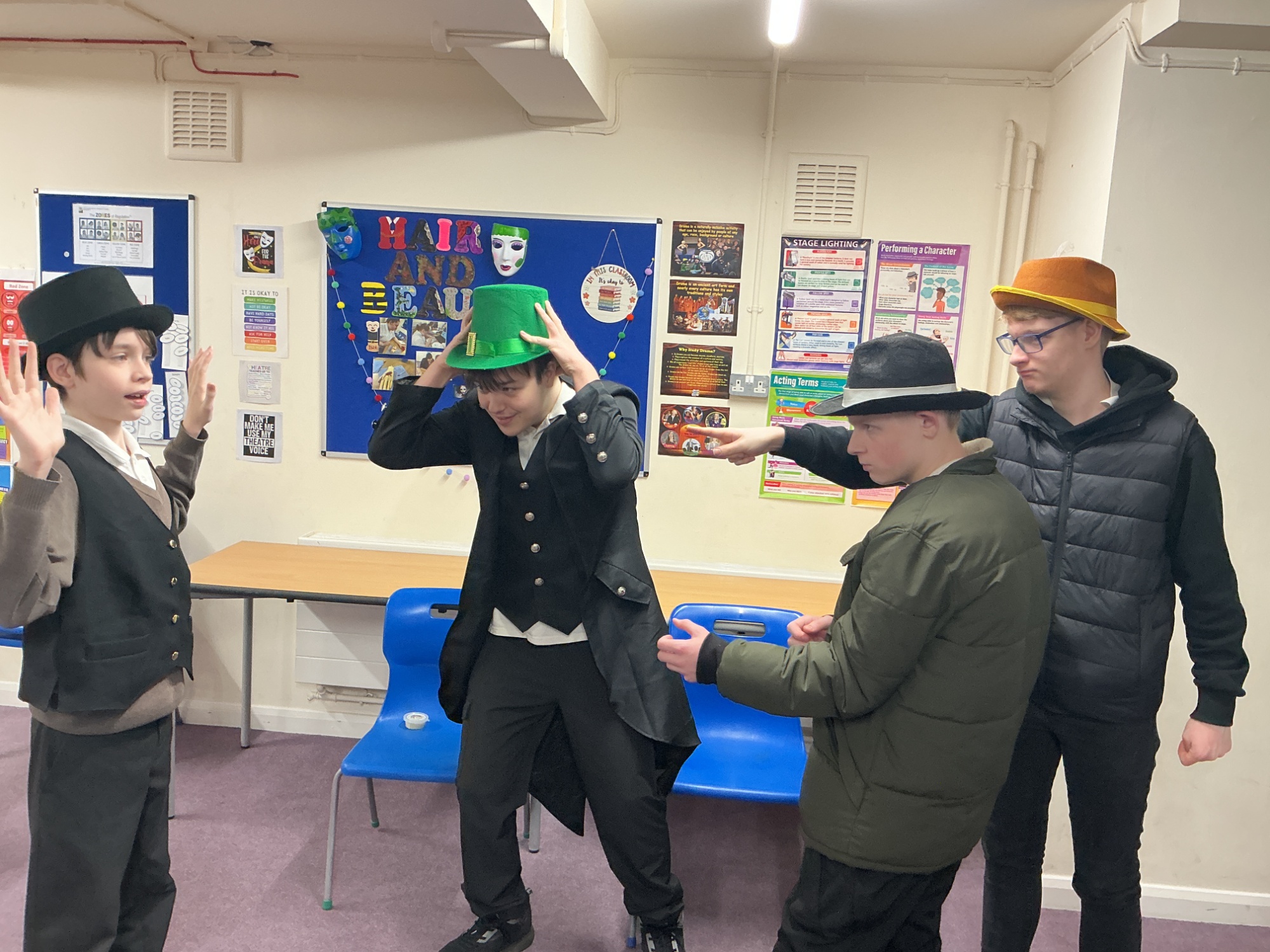 Four boys in hats acting out holding up another boy