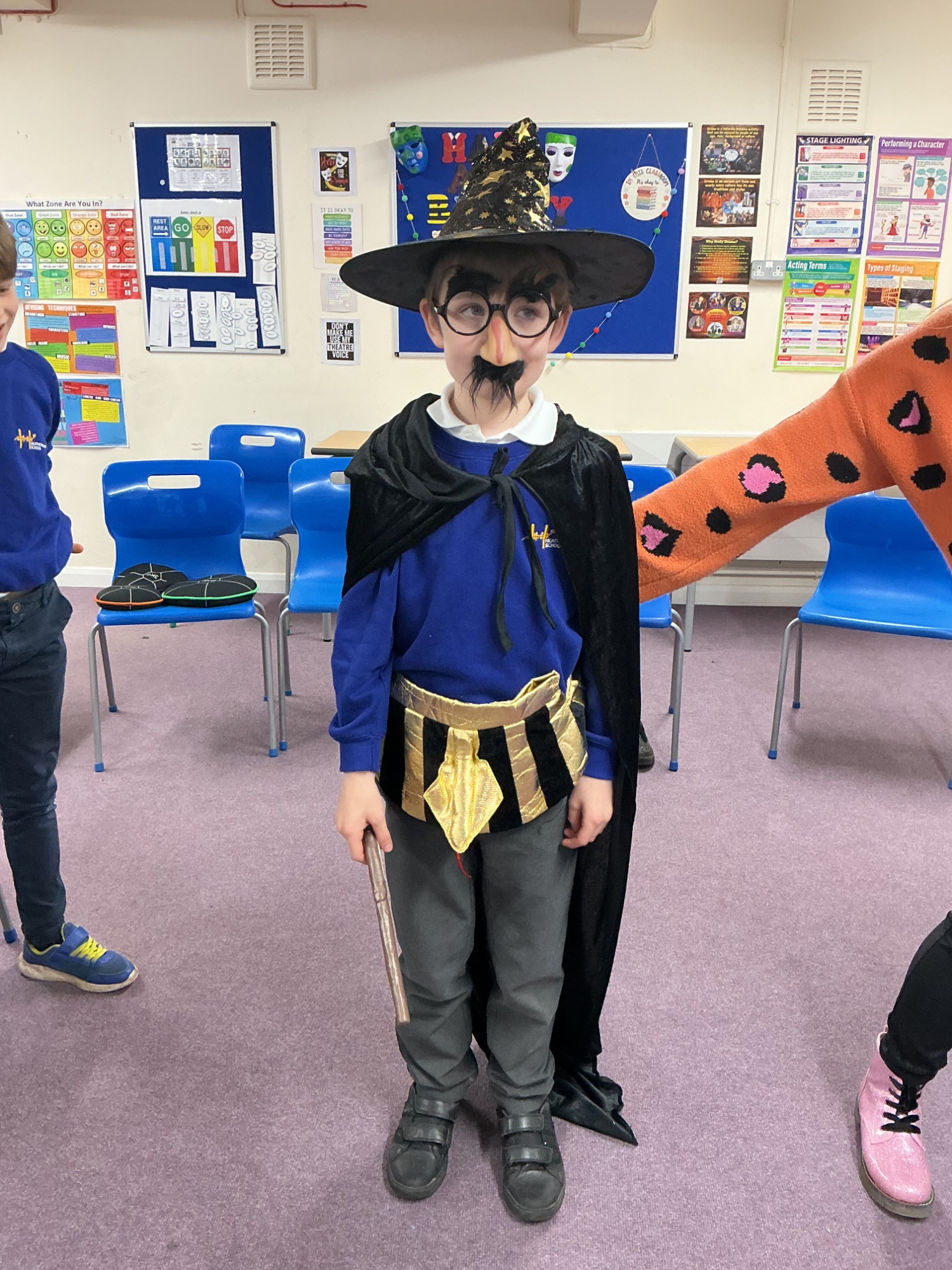 Boy from Elm wearing a hat, cape, glasses and belt