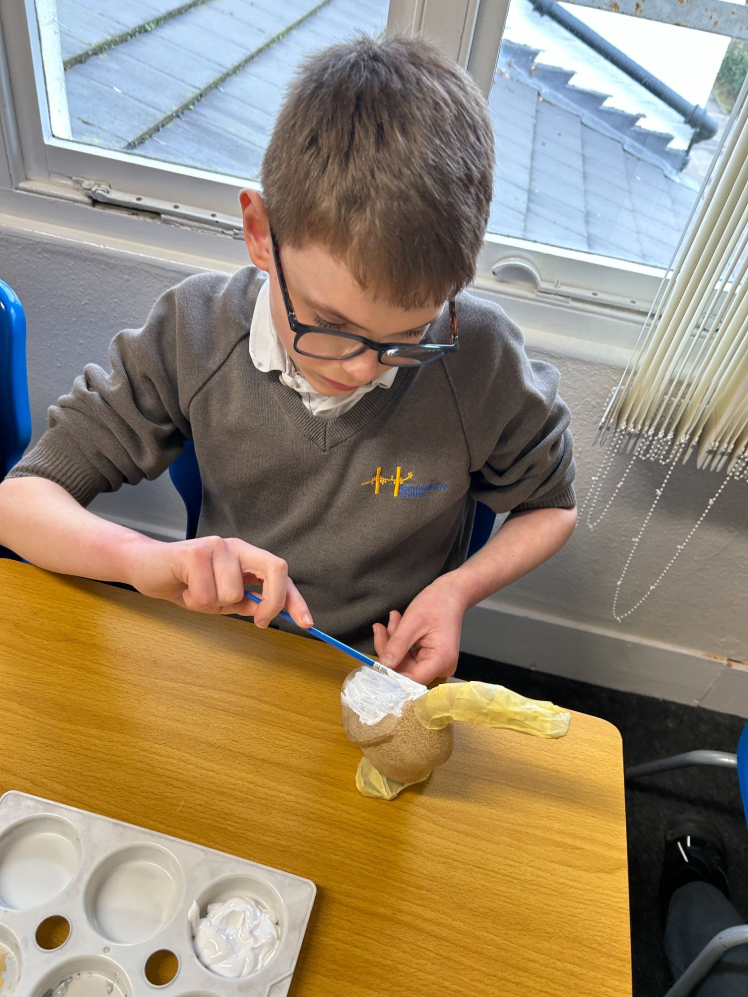 Boy painting his duck white