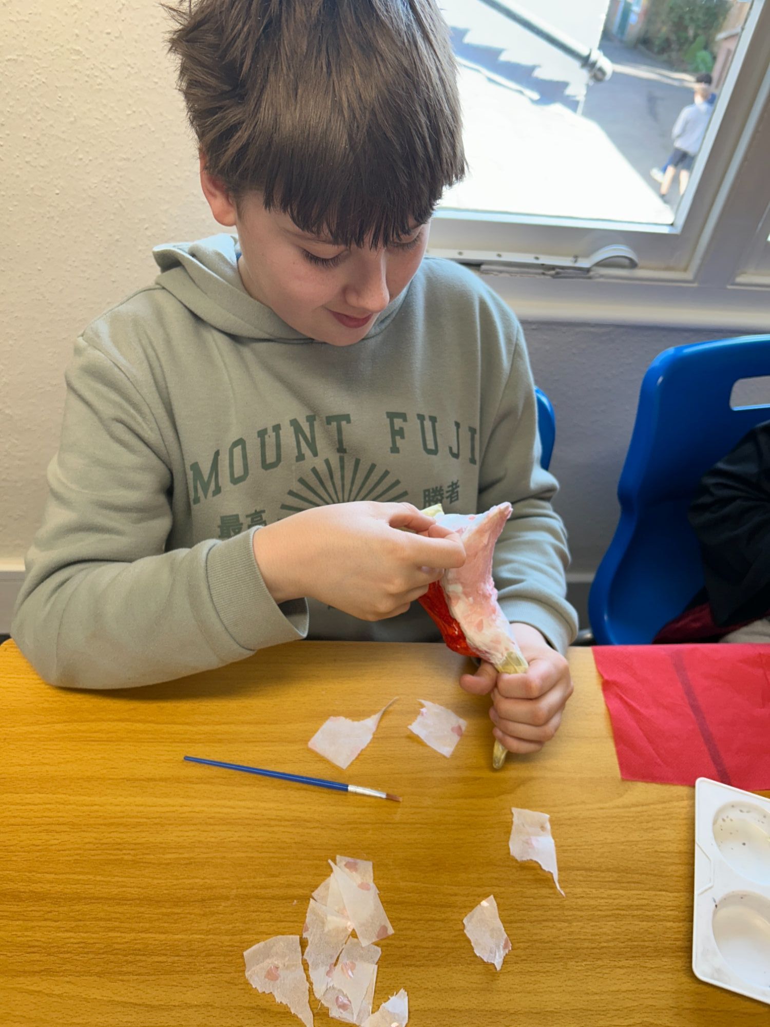 Boy focusing on adding paper to his duck