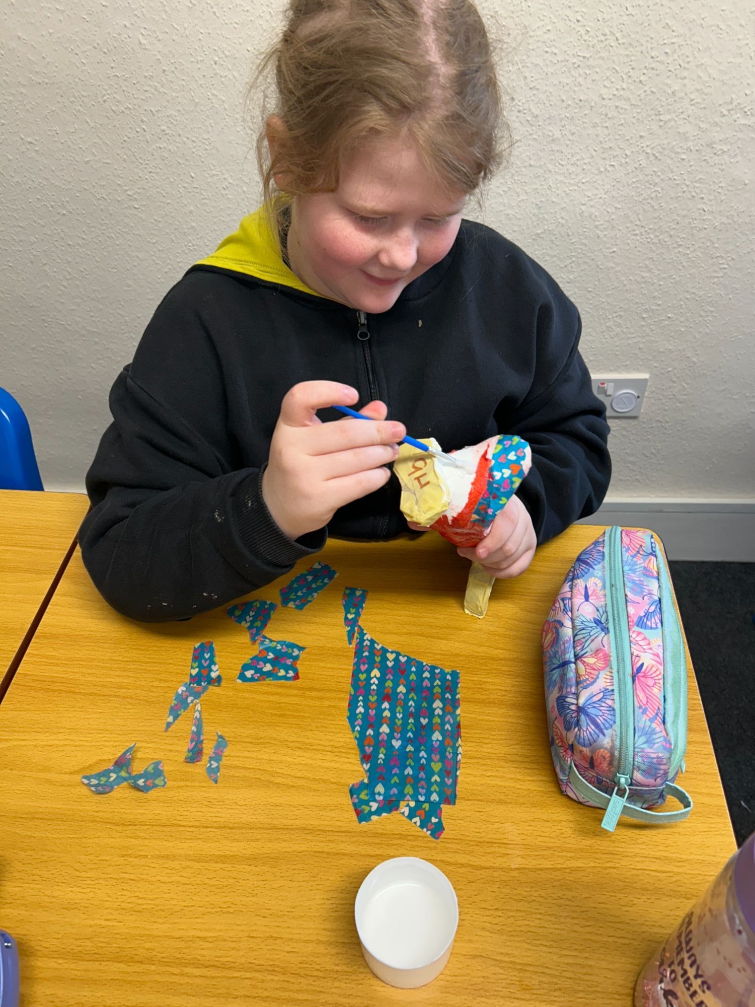 Girl adding tissue paper to her duck
