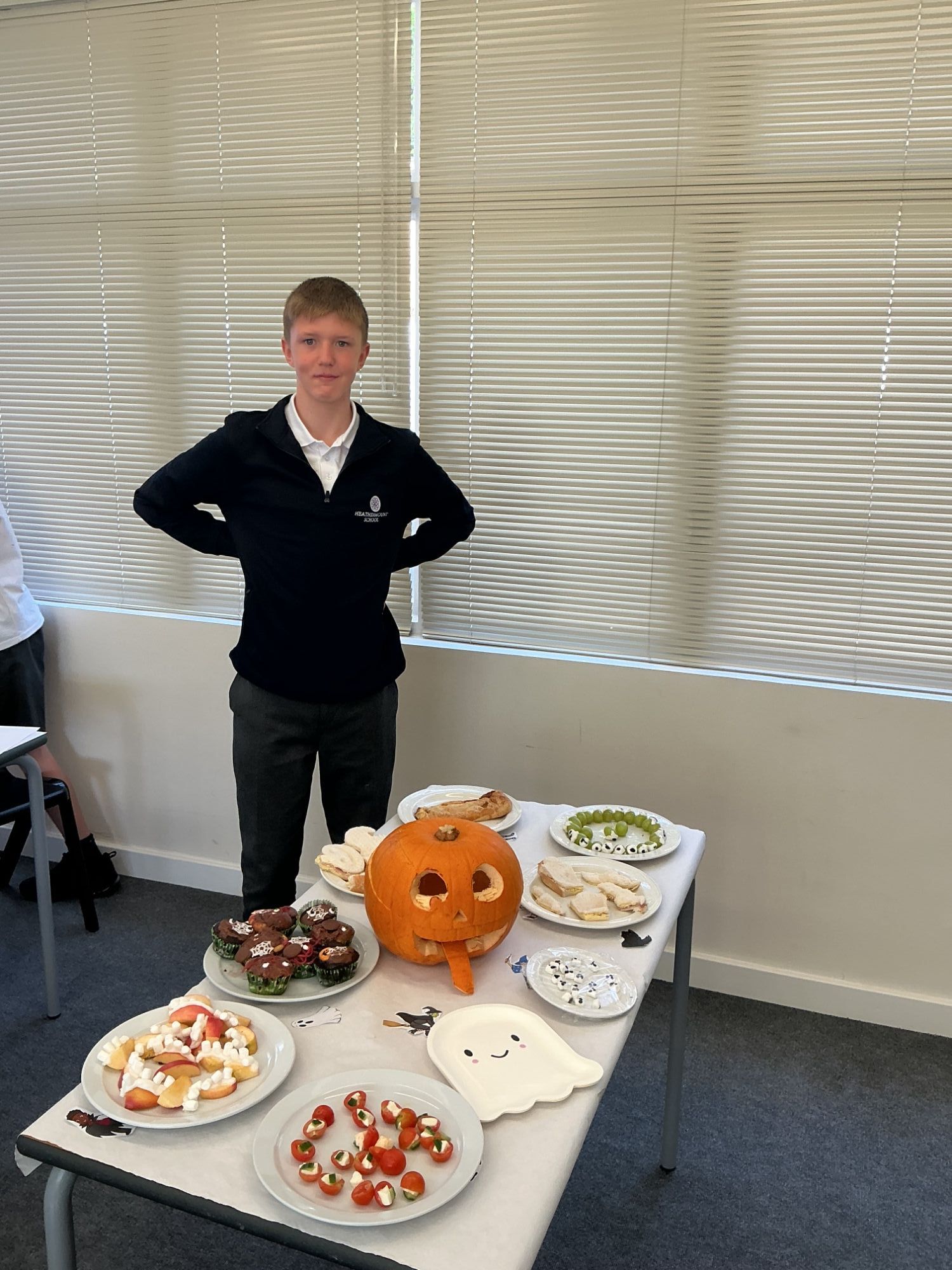 Halloween display Student standing by the table of party food