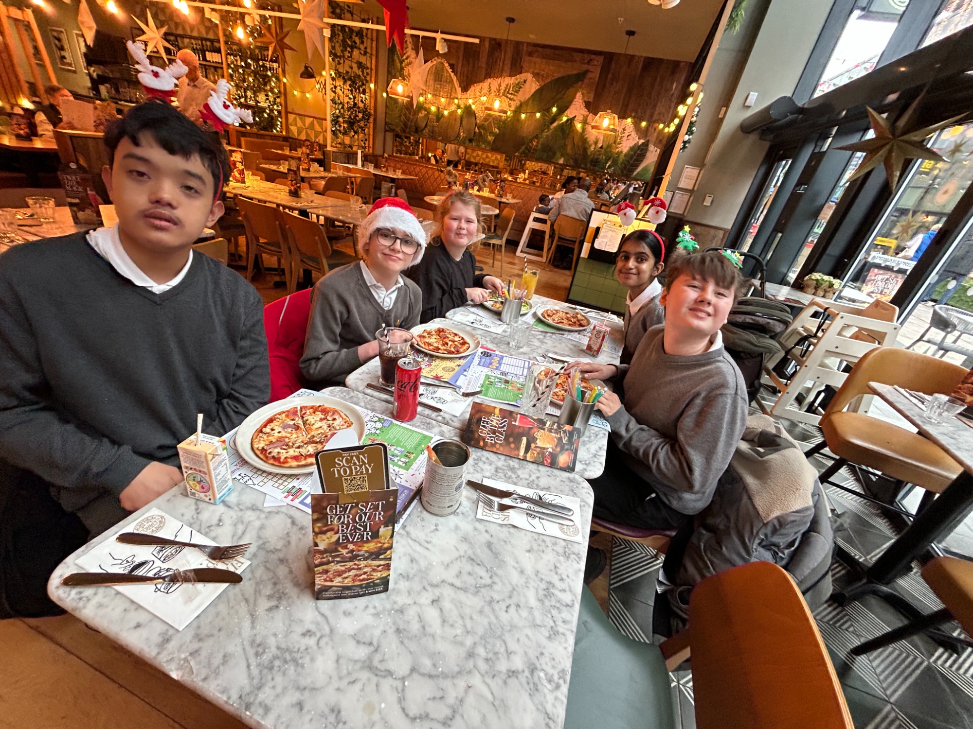 Earth class sitting together with their pizzas
