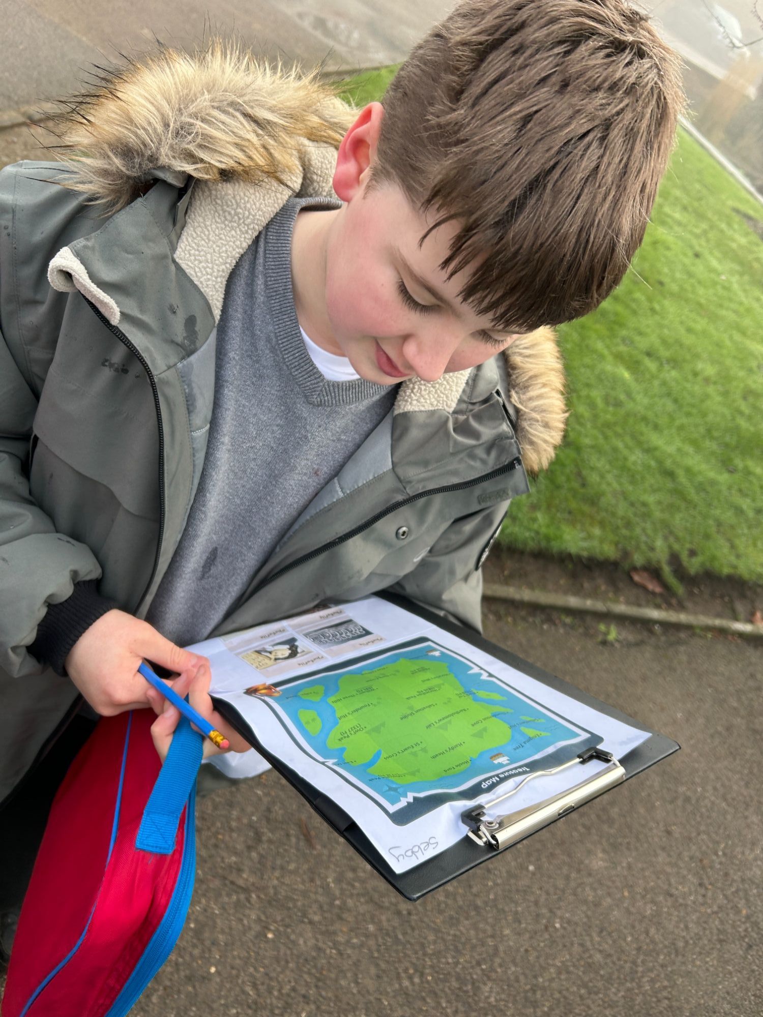 Male students holding a clipboard with a map on
