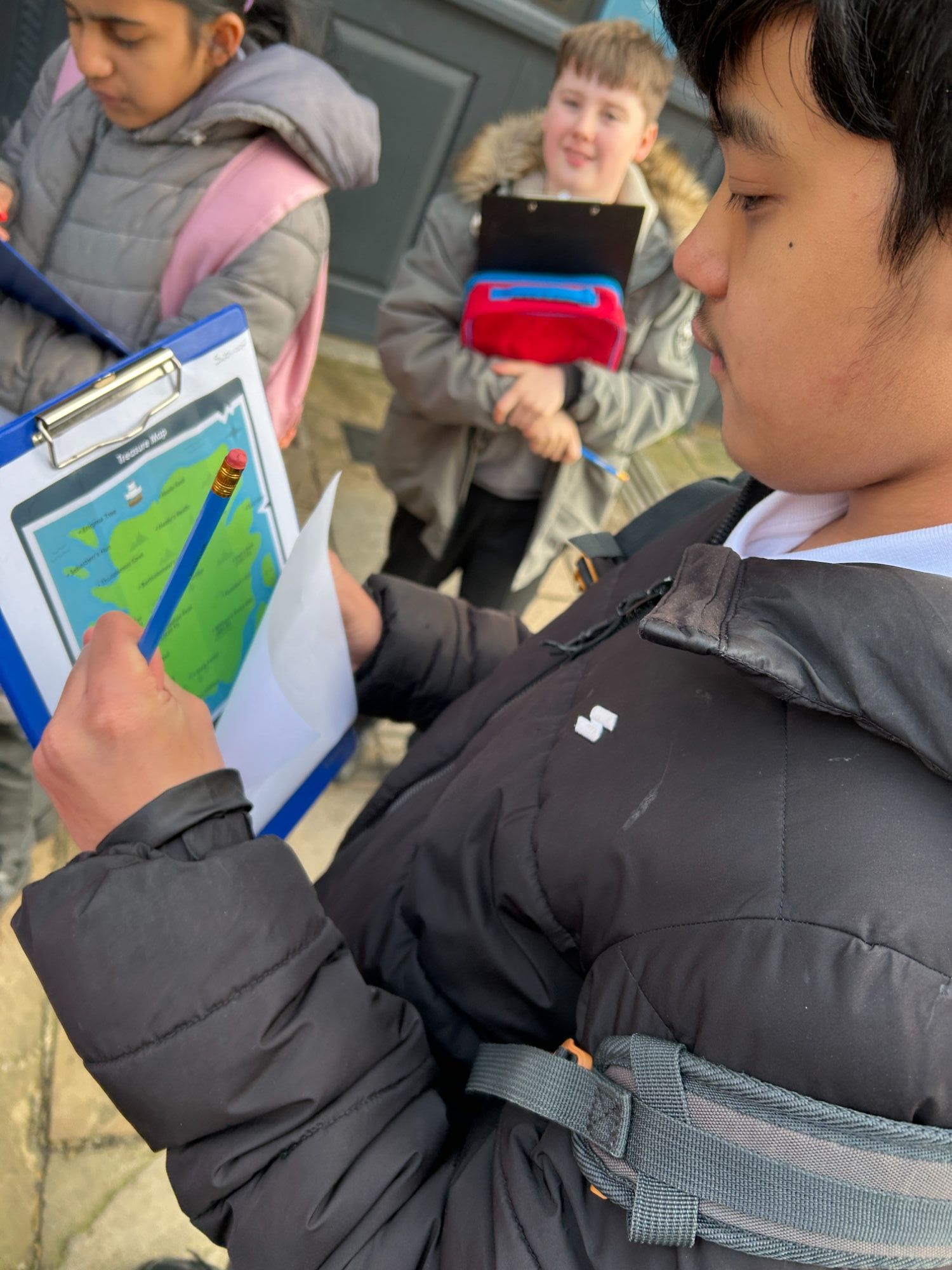 Male student holding clipboard and map