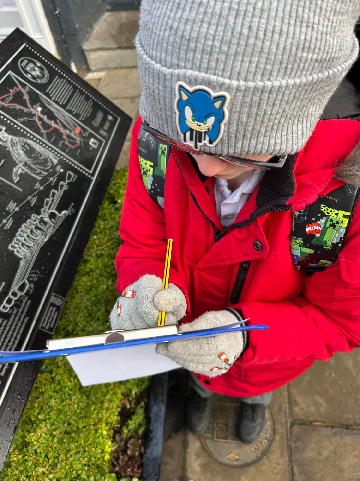 Male student recording a clue by a sign