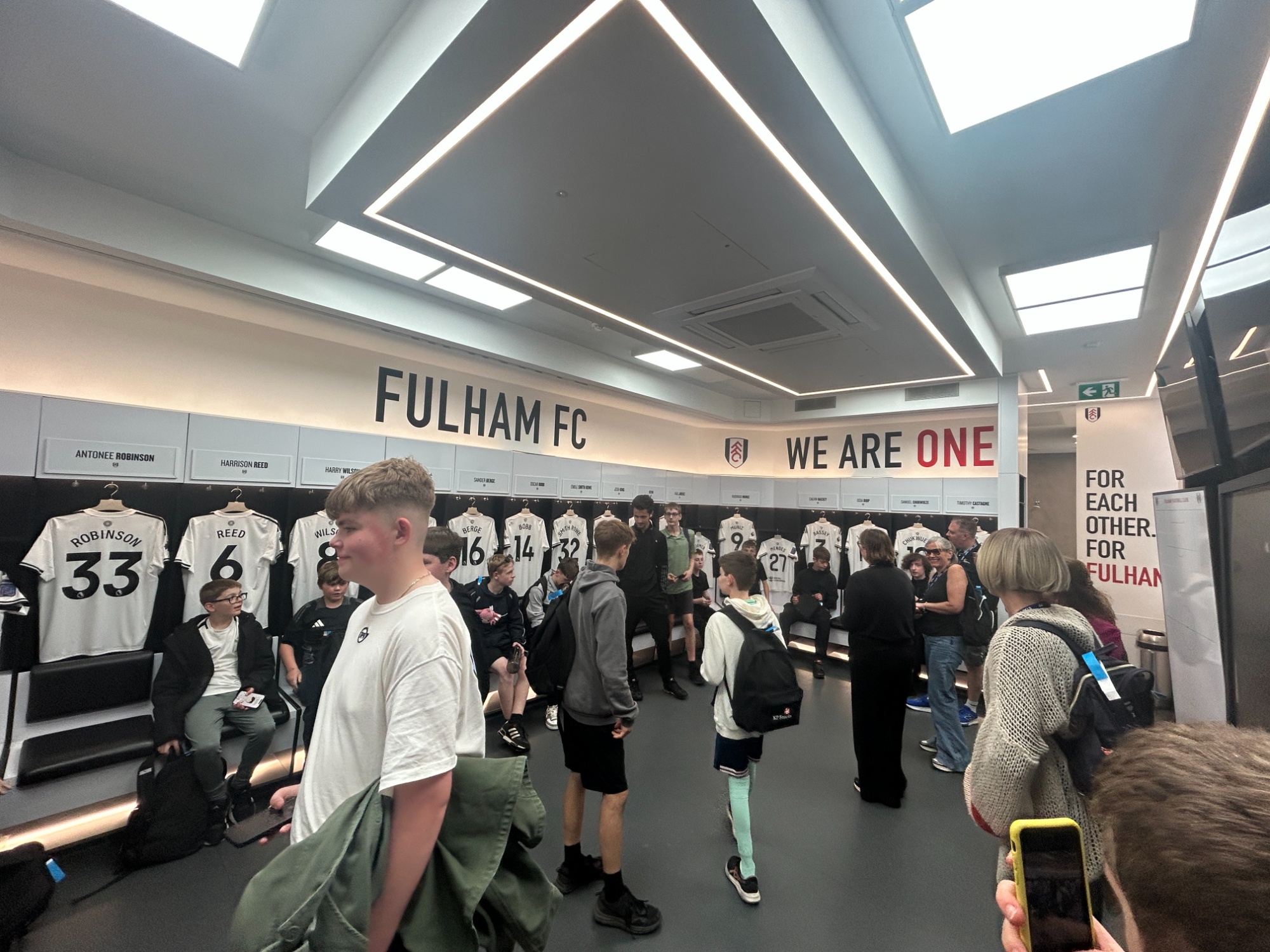 Students looking at the changing rooms and the Fulham shirts inside