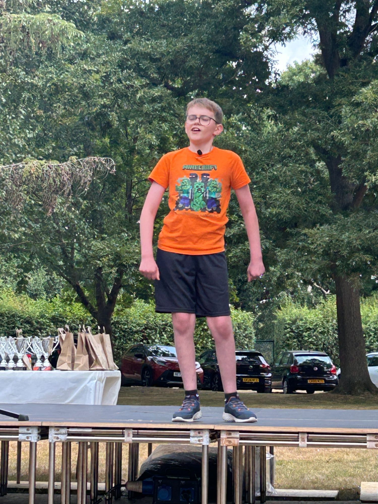 Boy on stage singing a song from The Greatest Showman