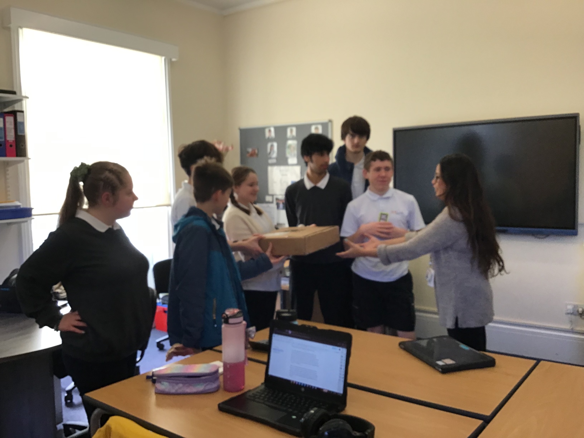 Students passing on a completed T-shirt order