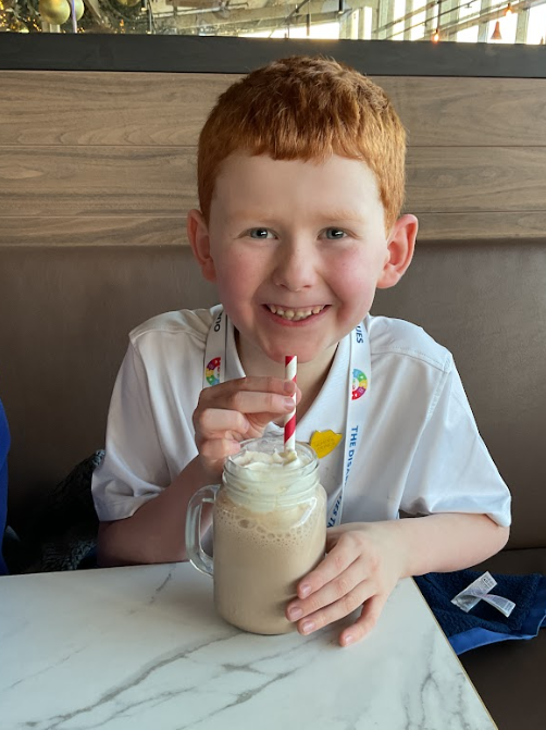 Student smiling with his milkshake