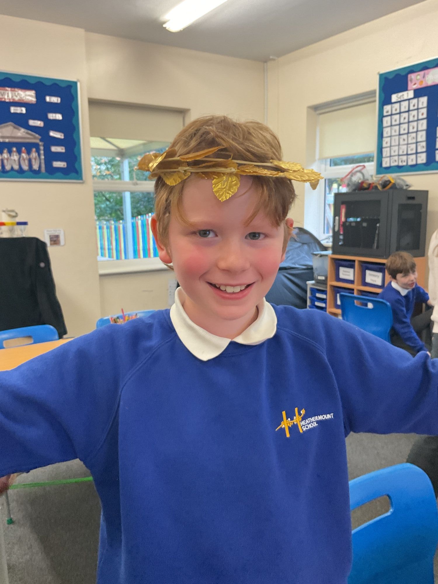 Student smiling wearing a gold wreath