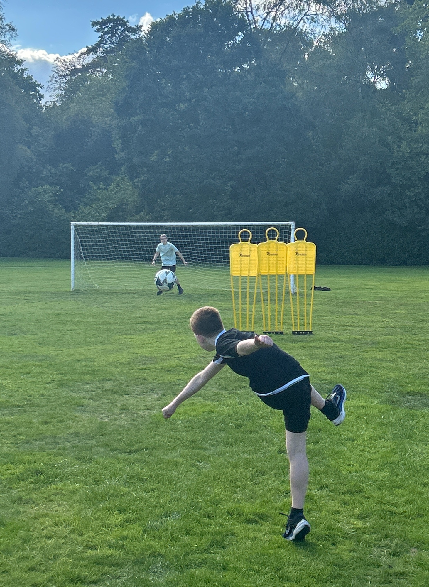 Student kicking a football Student kicking a football to goal round models of defenders