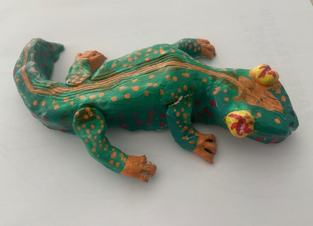 Clay gecko painted green with yellow spots