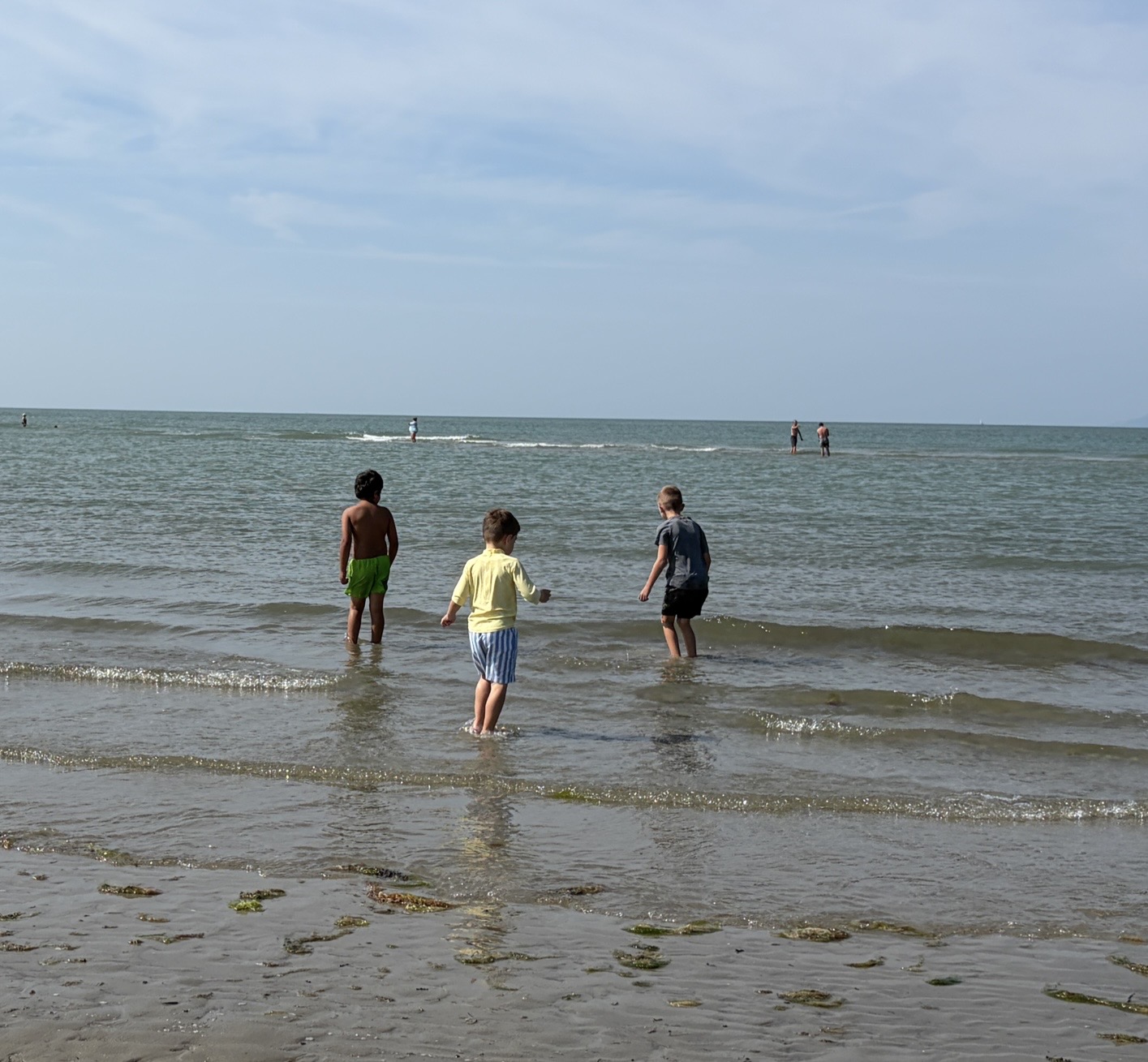 Three children paddling at the seaside