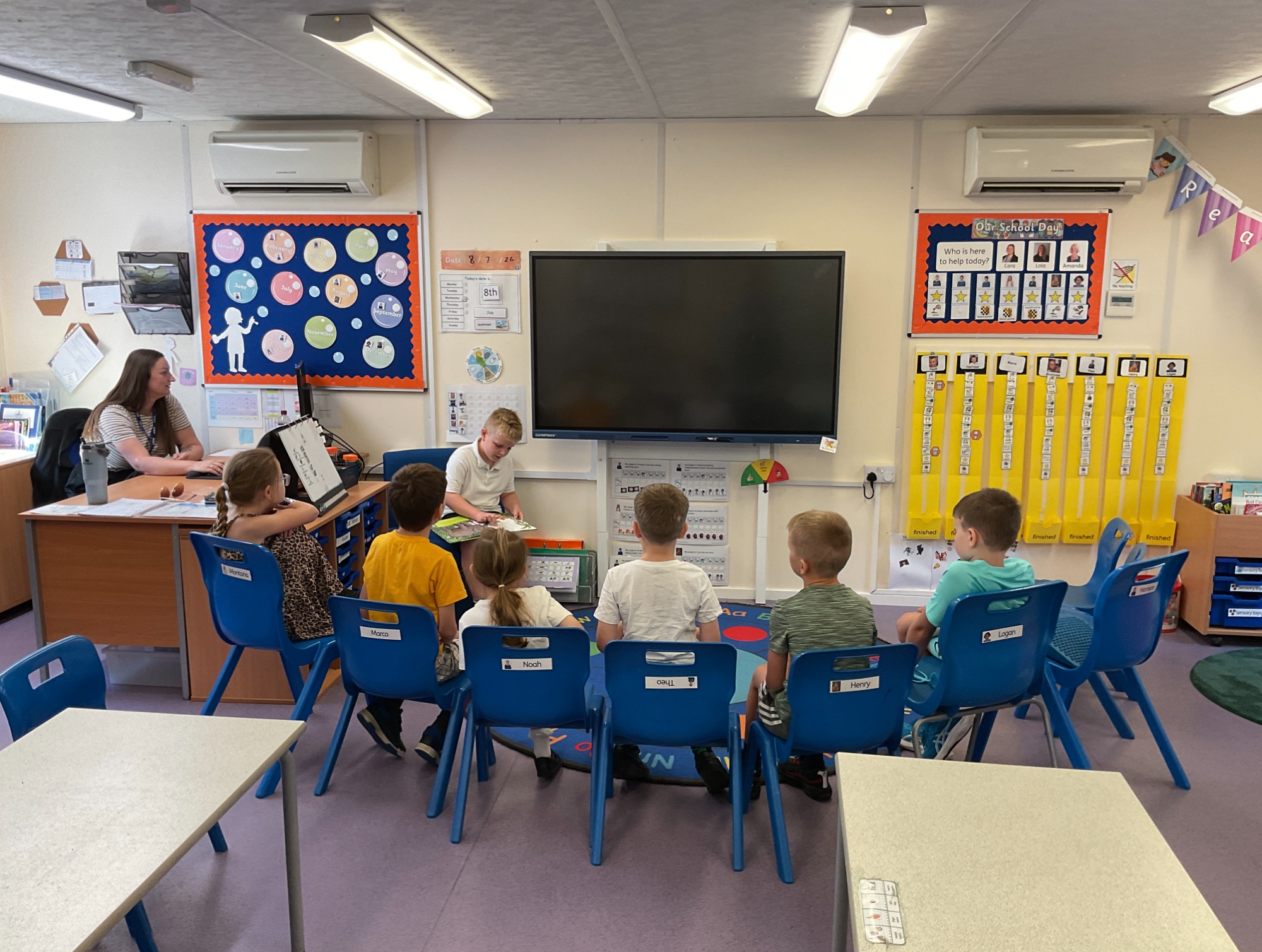Apple class Apple class sat in a semi circle in front of the white board