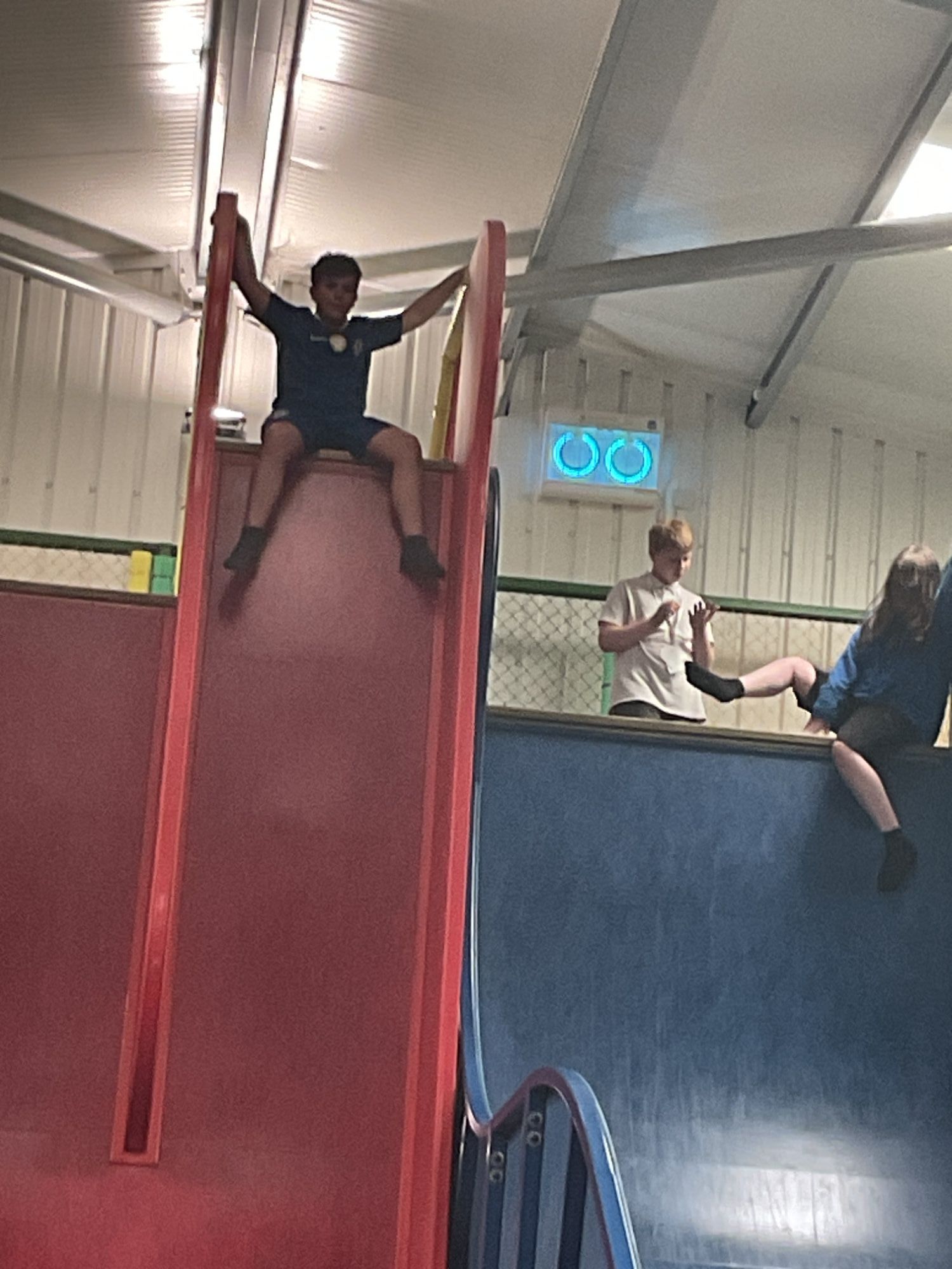 Another student about to go down a very steep red slide