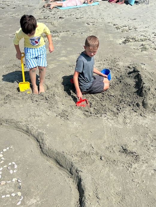 Digging Two boys digging on the beach
