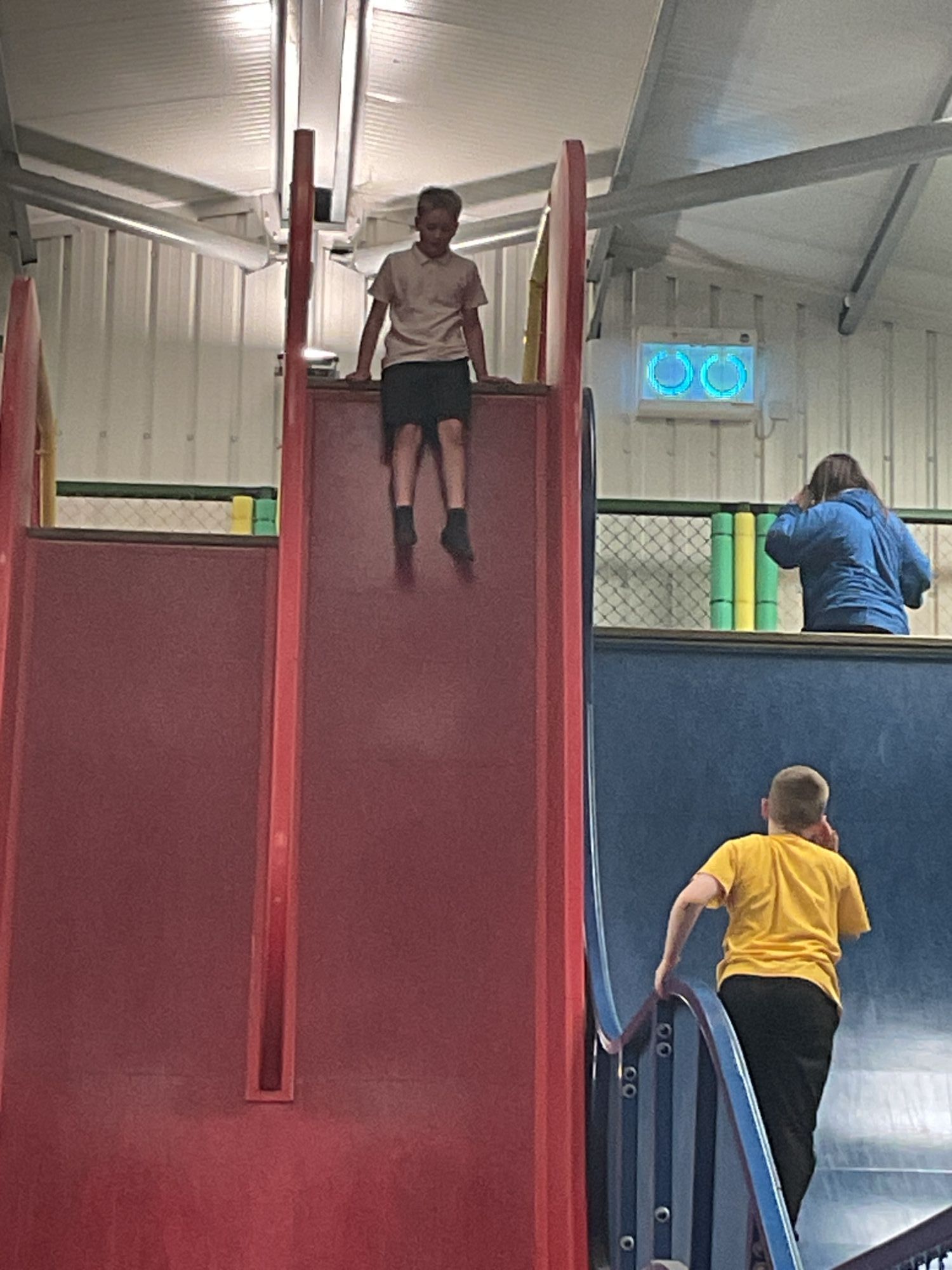 Student about to go down a very steep red slide