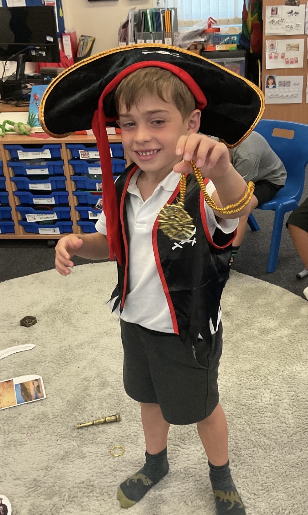 Boy smiling dressed up as a pirate and holding treasure